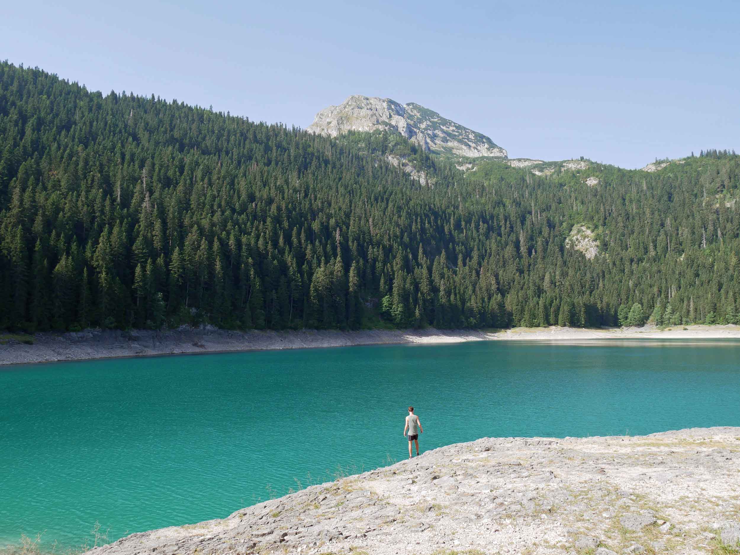  The calm waters of the Black Lake reflect the dark greens and blues of the evergreens and pines beyond.&nbsp; 