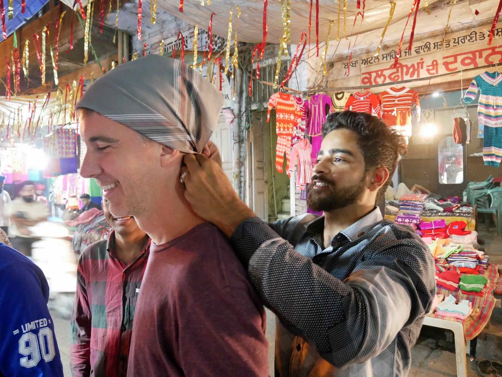  In order to enter the Golden Temple, men must cover their hair and remove their shoes – here, Trey gets fitted with a bandana. 