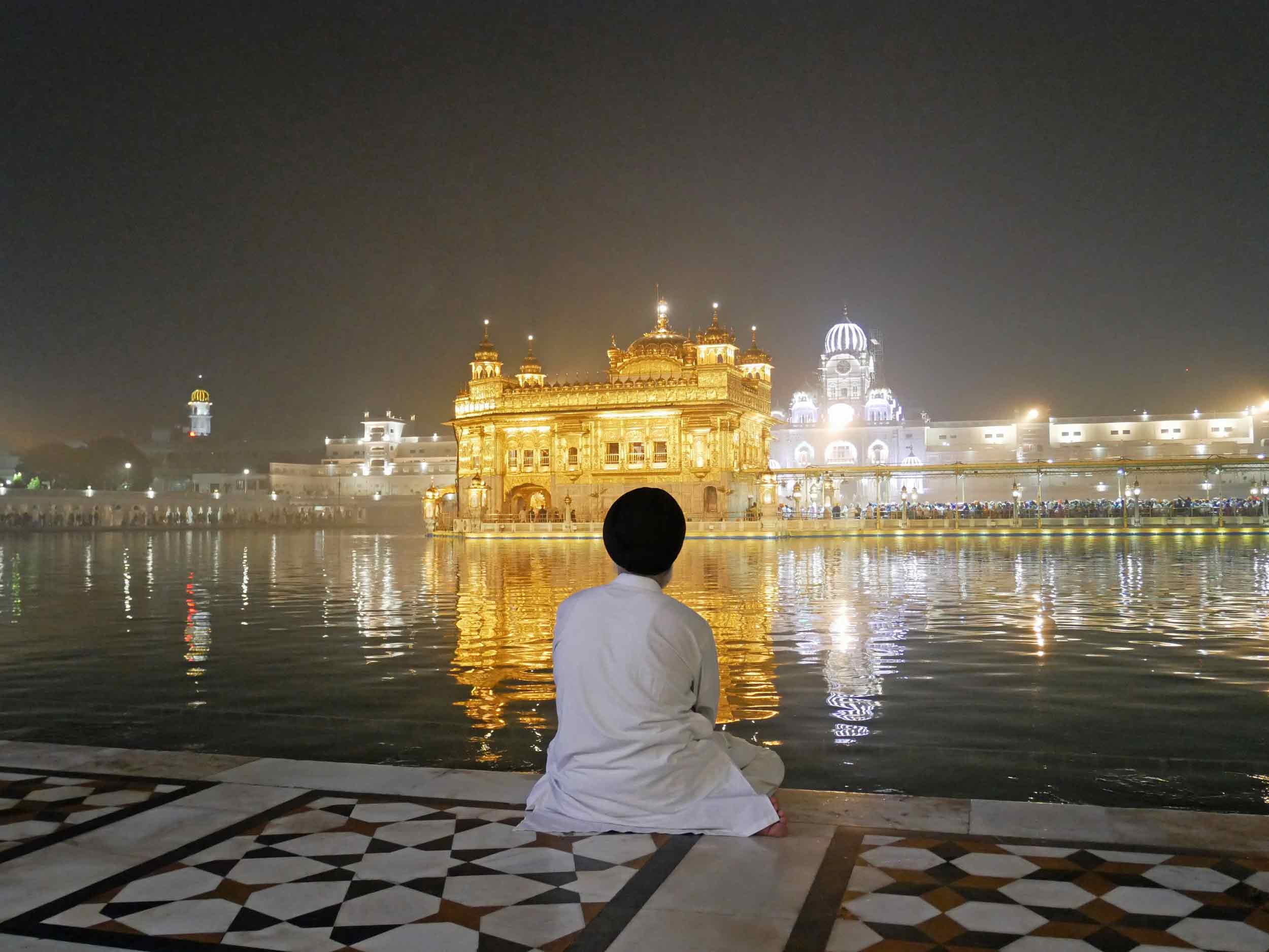 The Golden Temple, resplendent in its evening glow, seemingly floats atop the holy waters that surround the sacred inner-sanctum. 