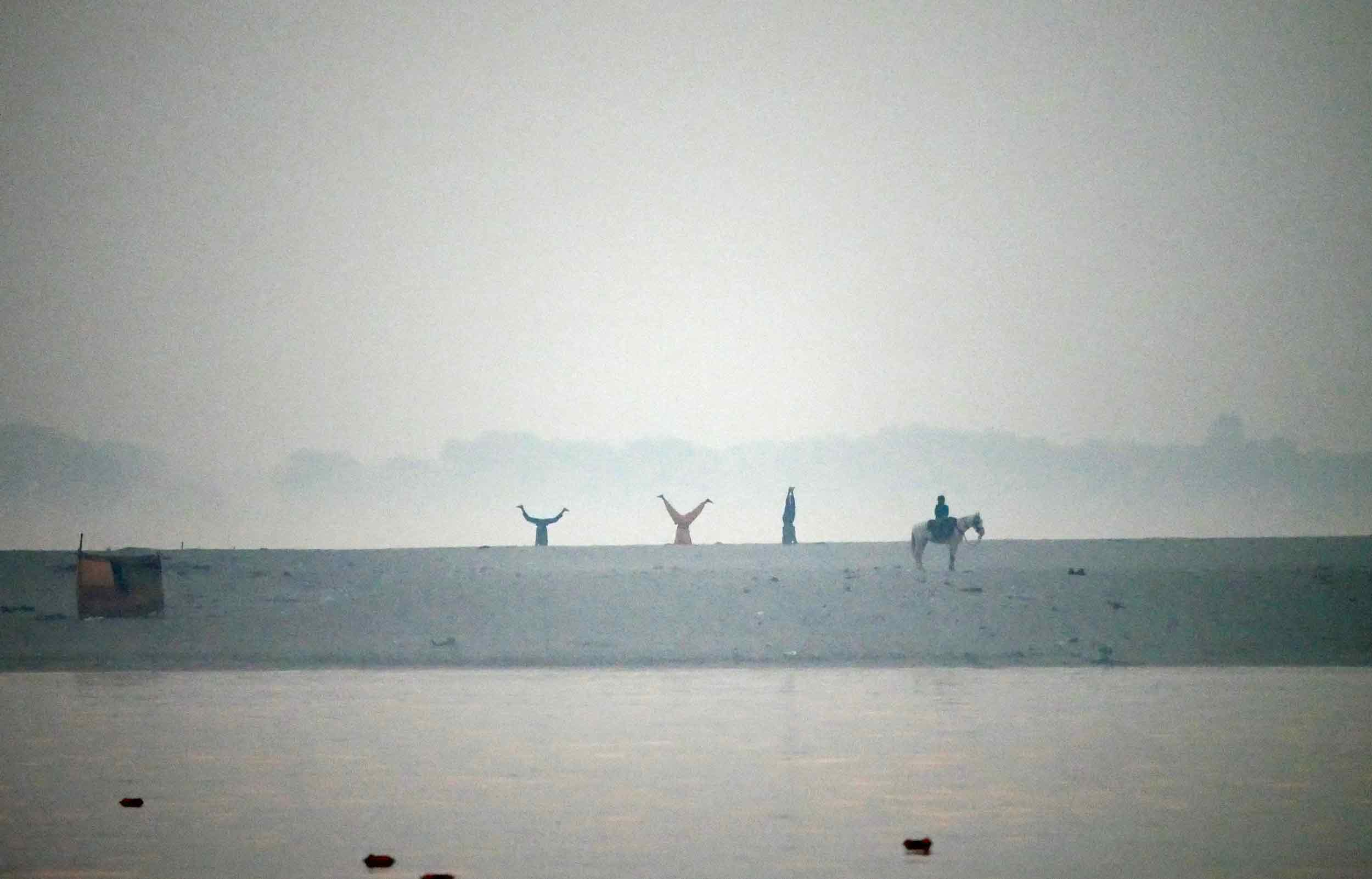  Yoga being practiced across the river on its sandy shore. 