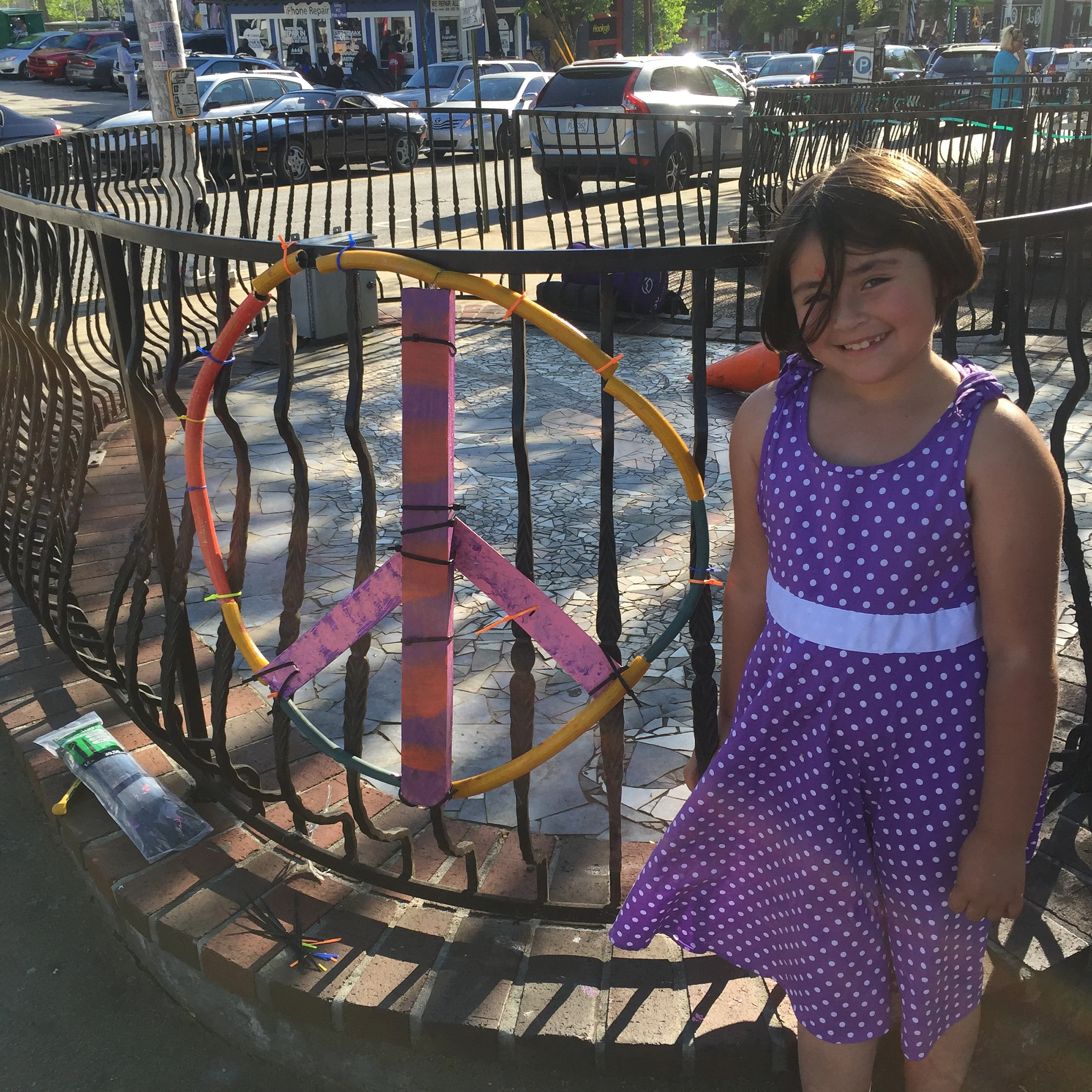  She walked up and declared, "I want to make a peace sign!" So we made one with painted plastic blinds, garden hose and zip ties. 