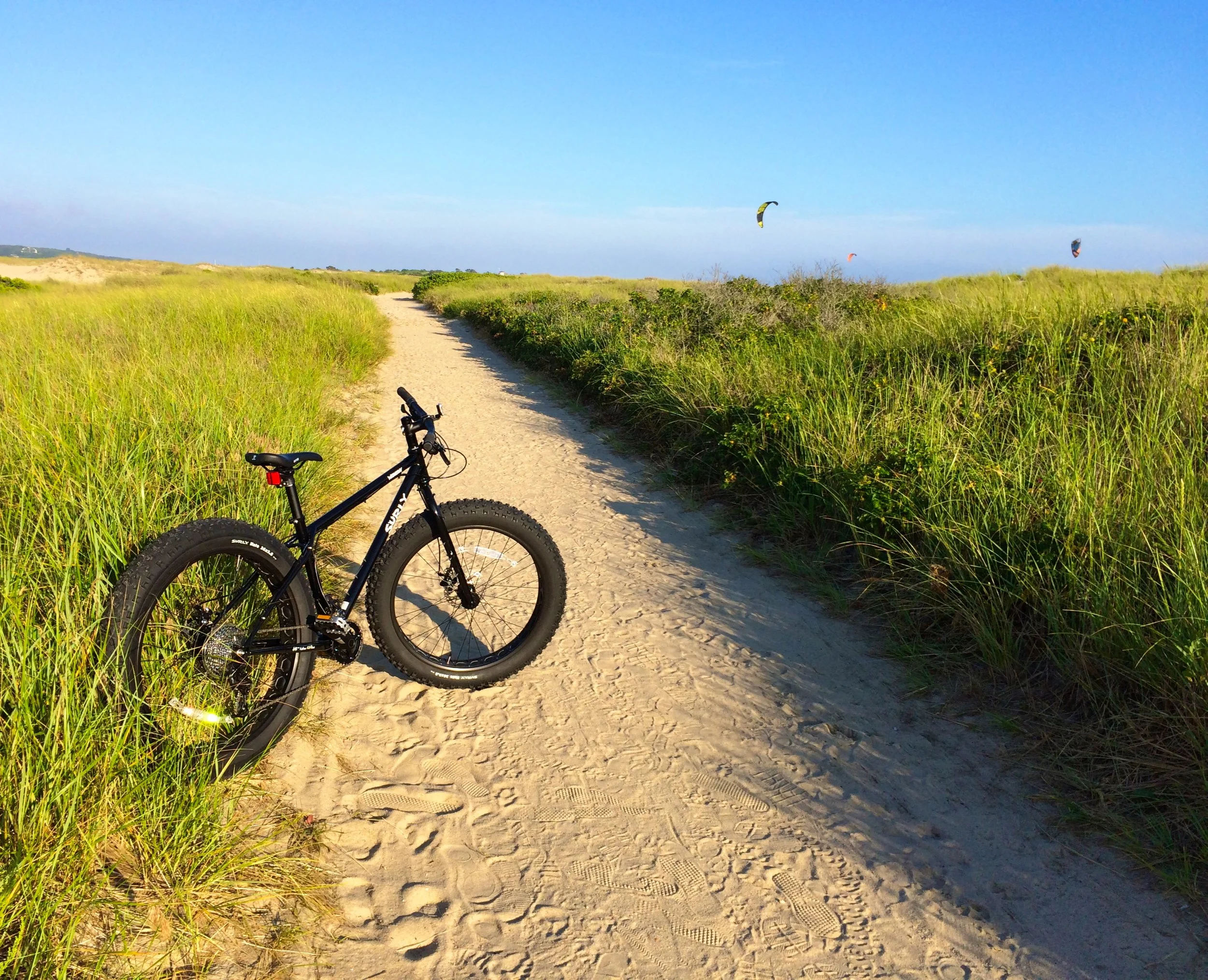 our Surly FatBike on the beach trail with Kiteboarders in the back ground