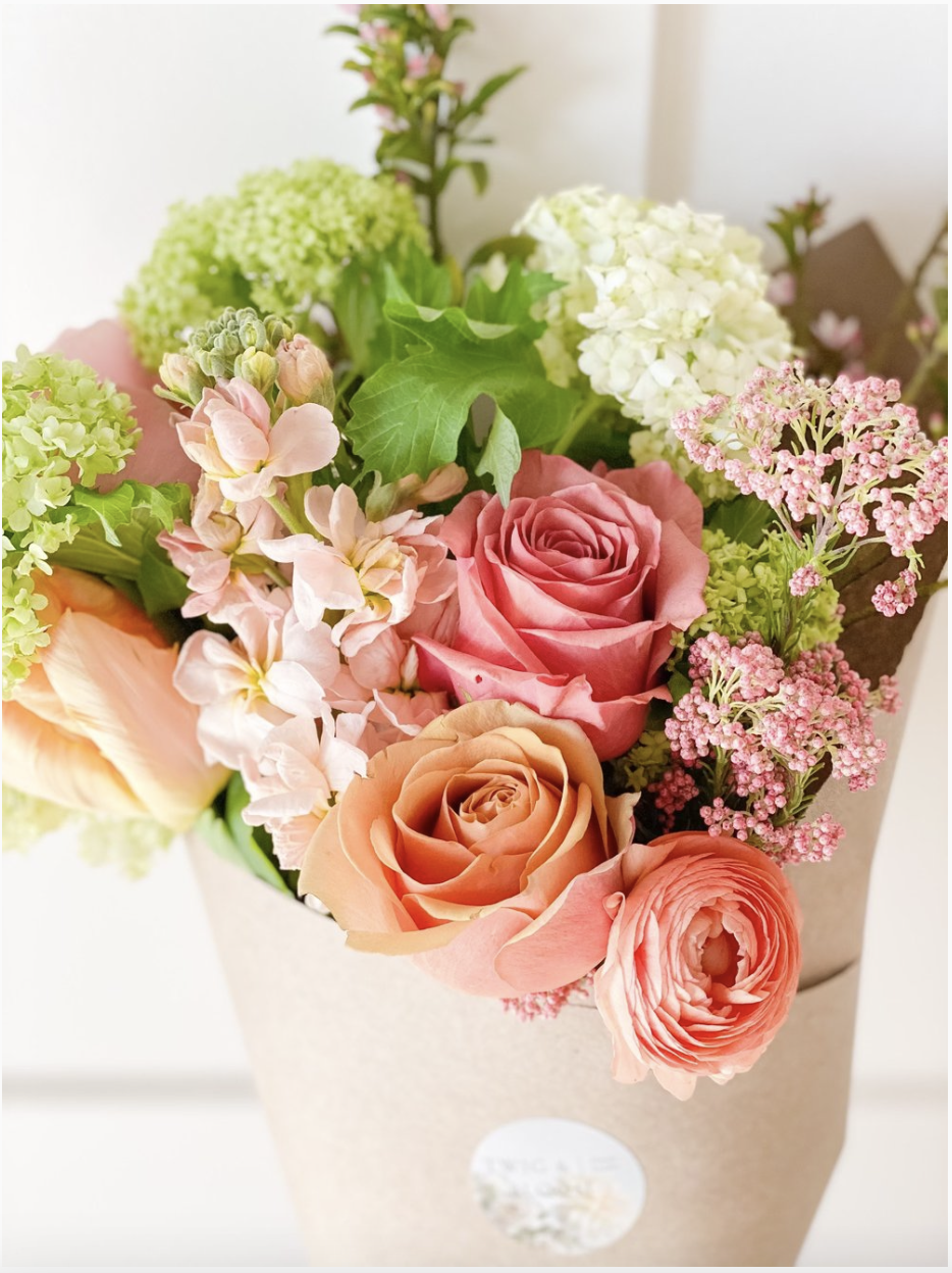 Pink and peach flowers wrapped in a bouquet designed by Twig & Bloom in Saskatoon