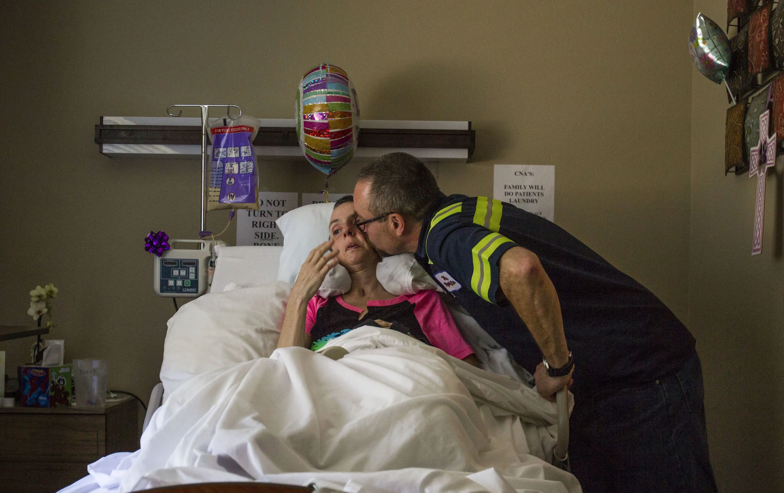  Tim Fink gives his wife Molly a kiss as she rests in her bed at Avamere Riverpark. Fink has used GoFundMe as a resource to help raise money for the medical expenses associated with his wife's accident. (Rhianna Gelhart/The Register-Guard) 