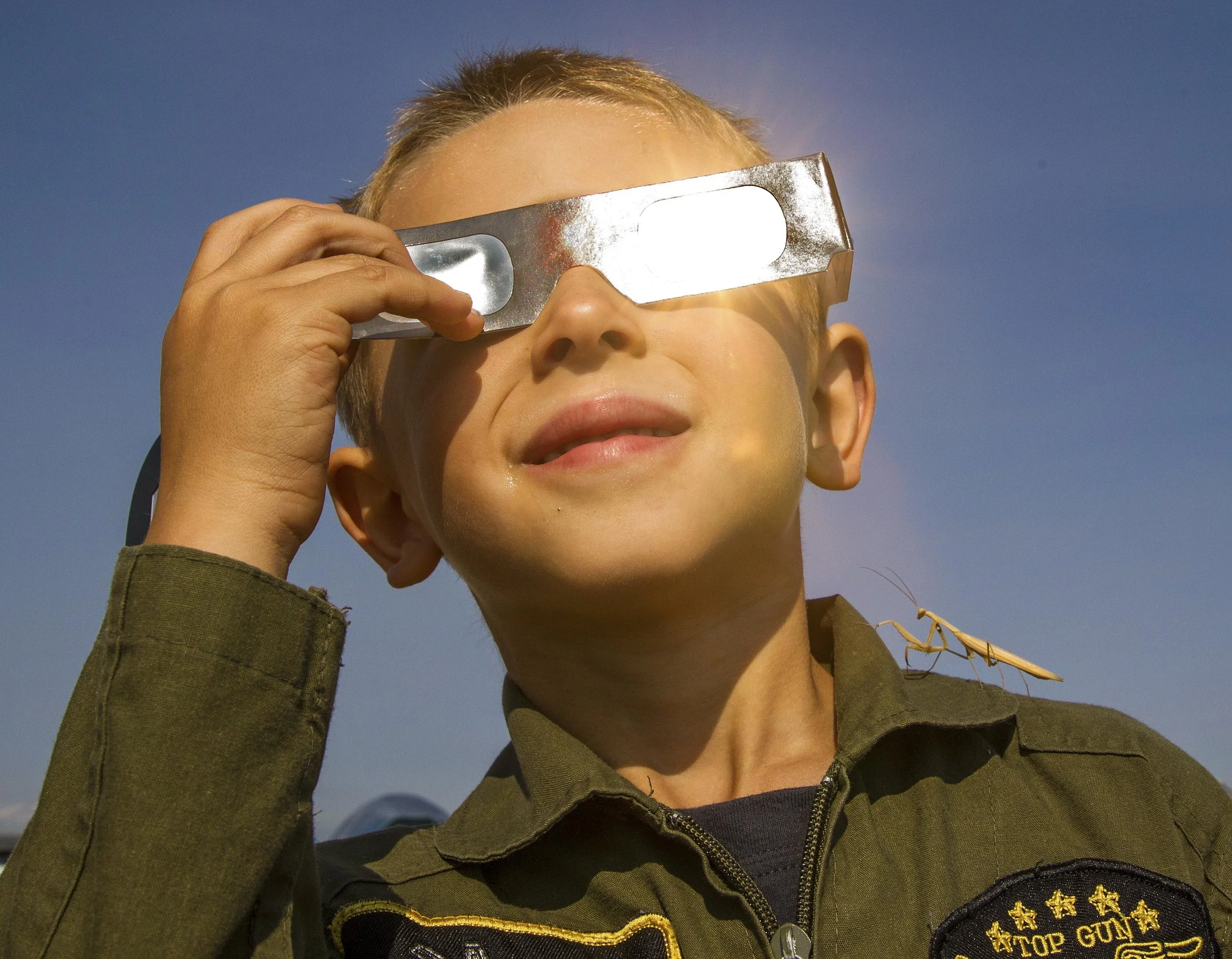  Calvin Suhr ,5, and his preying mantis friend watch the total solar eclipse as it makes its way towards totality at Madras Municipal Airport on Monday, August 21, 2017 at 9:58am. 