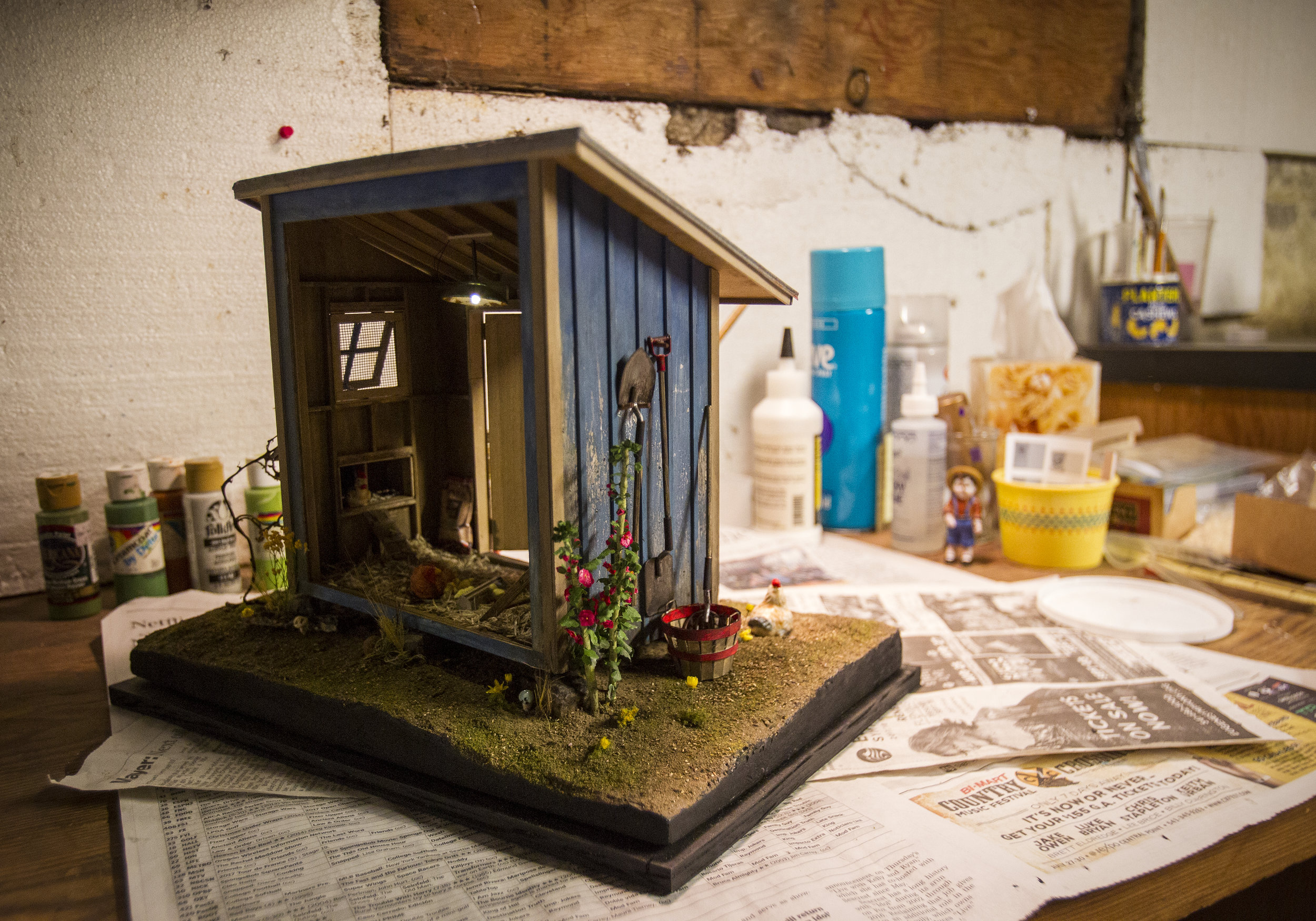  Joanne Snyder's chicken coop sits on a work bench in her basement. The Eugene Minis Club members pride themselves on making nearly every piece of their models from scratch. Snyder made her hollyhocks for her chicken coop and each hollyhock has anywh