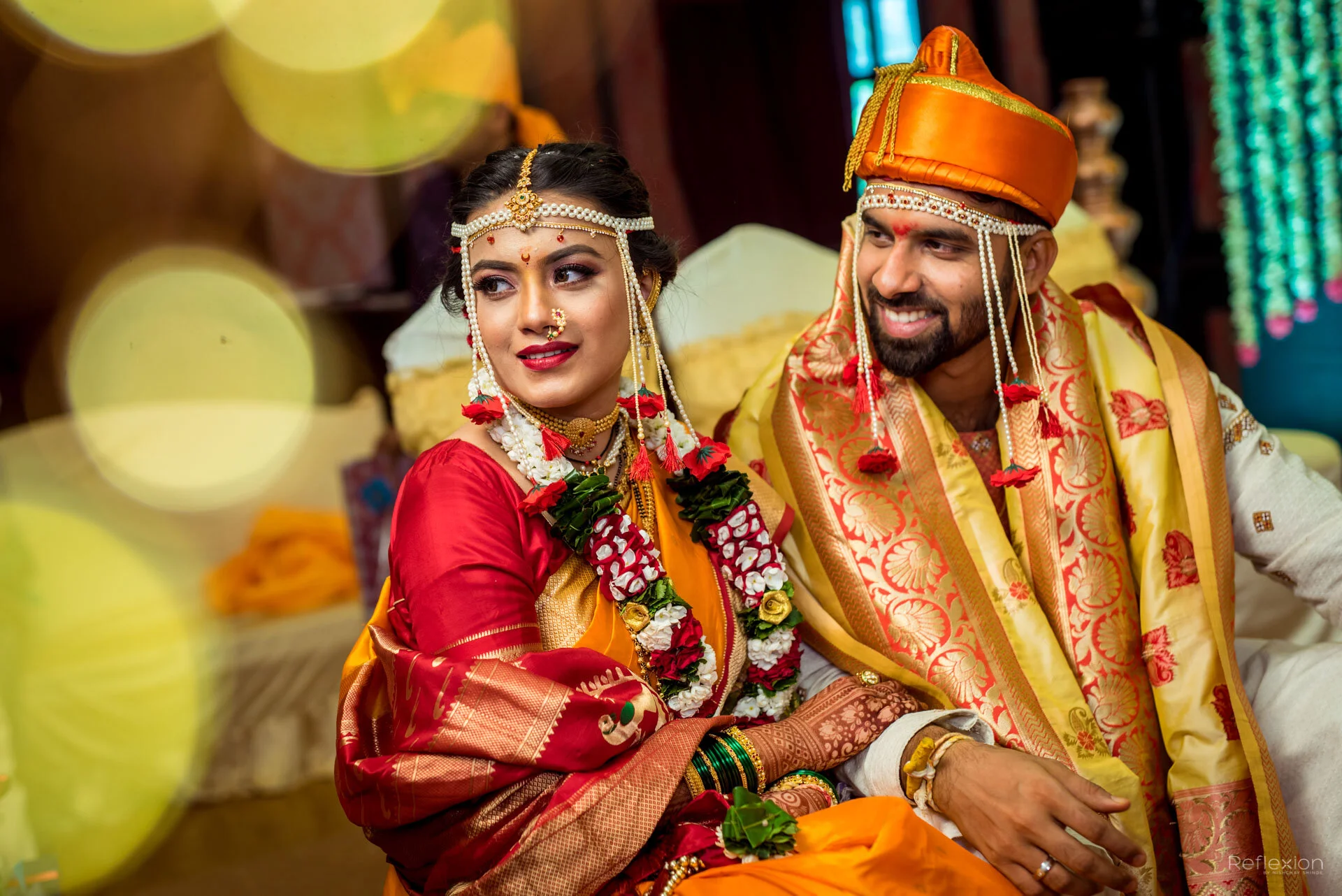 Indian bride and groom dressed in traditional wedding attire, seated together during a wedding ceremony.