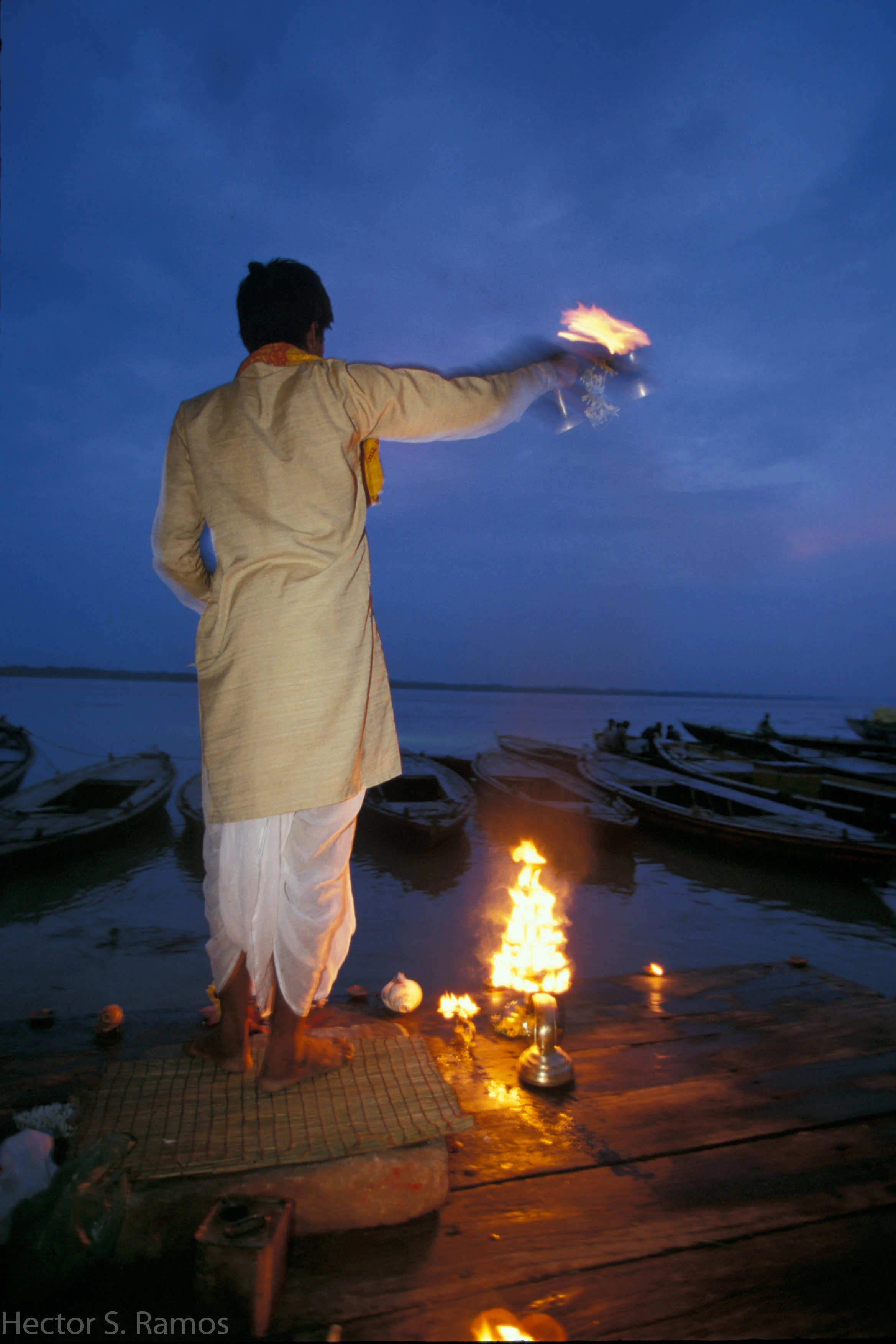 Evening aarti. Varanasi. During a monsoon there were not many people at the river Ganga. This pujari kept up with his daily ritual alone. It was beautiful to witness - sincere devotion. It brought deep stillness in me. Photo: Nikon F5, 20-35mm f2.8, SB-28 flash, Provia 100.