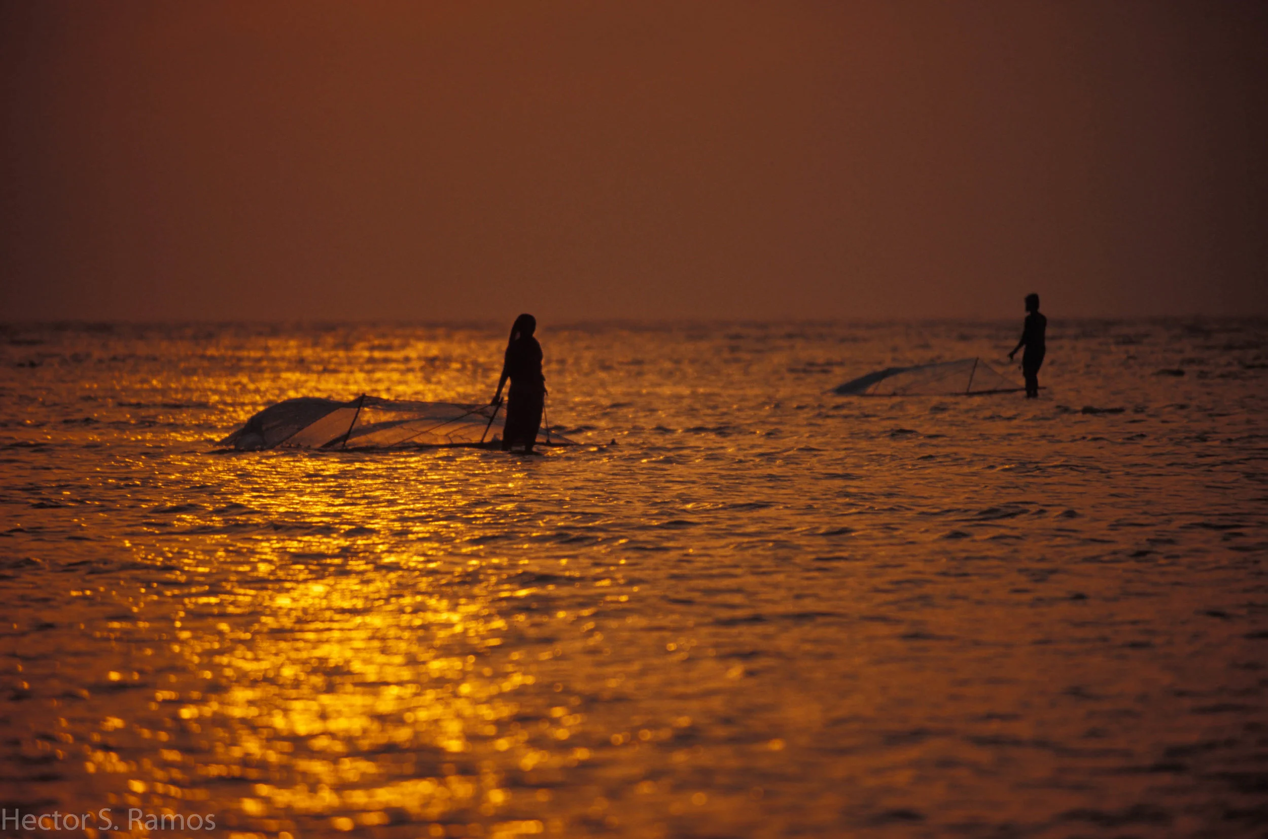 Fishing at sunrise. Orissa. I walked on a knee-deep calm water for several kilometers waiting for the sunrise. My reward was being a witness to this couple. Photo: Nikon F5, AFD 80-200mm f2.8, Provia 100.