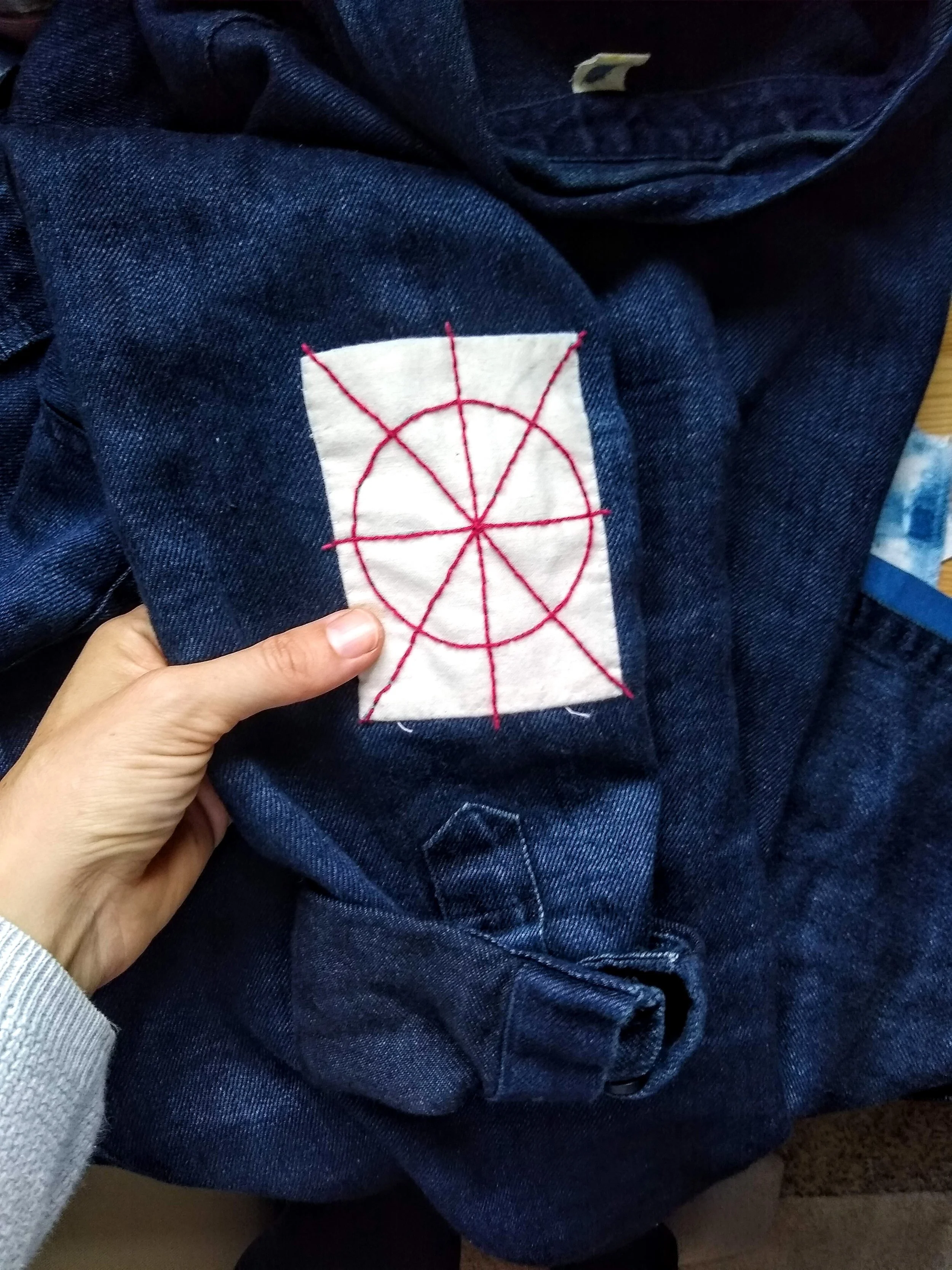 A basic fabric appliquéd patch with red sashiko top stitching to add strength and interest on an oversized denim shirt.