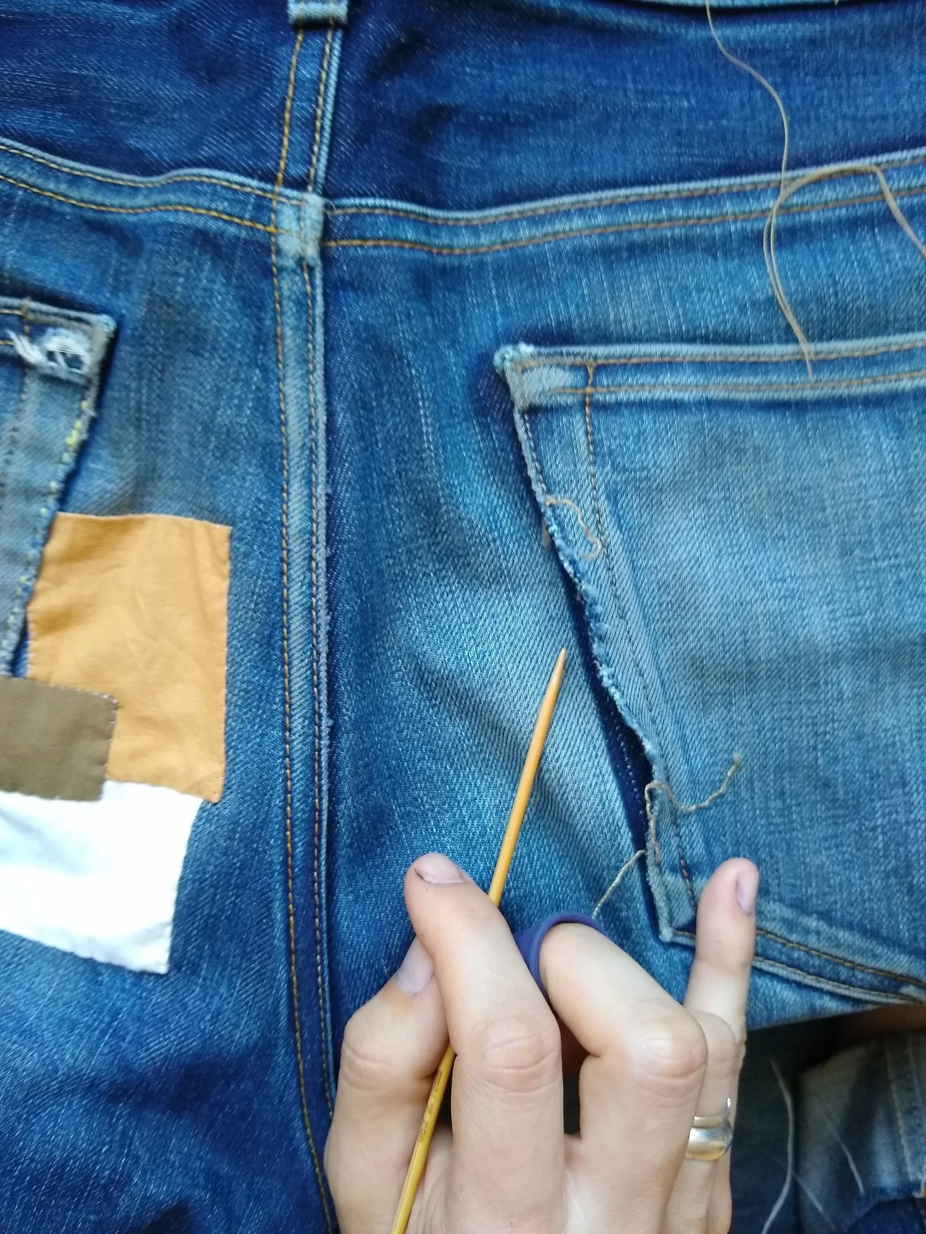 Carefully pulling out the original pocket stitching.