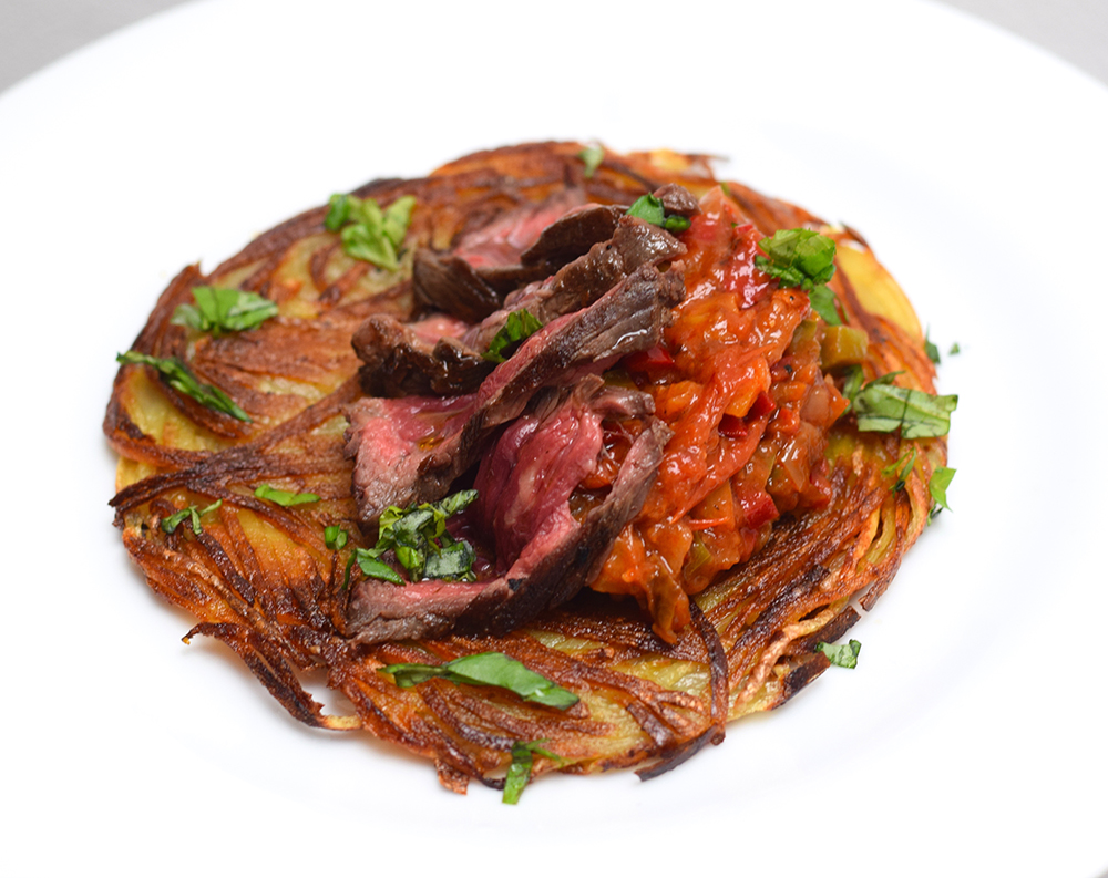 Steak and hash brown with sweet pepper and roasted tomato condiment and fresh coriander