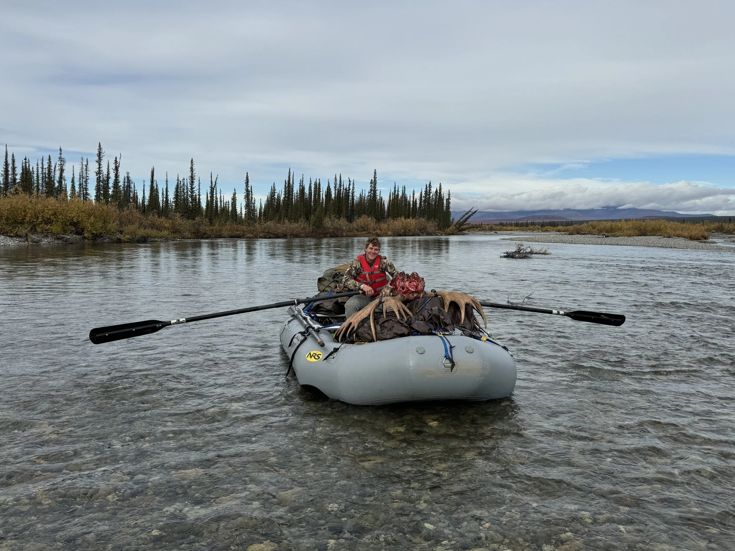 Guide Douglas L. rafting a client's trophy downriver for pickup