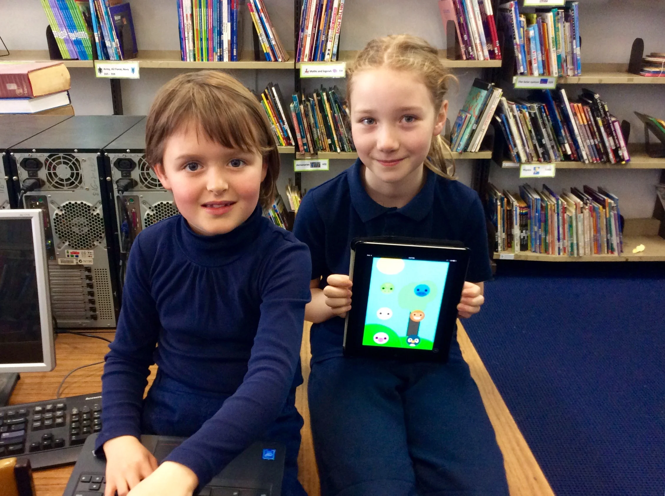 Nell & Poppy showing the app they made which is available on the Apple App Store.
