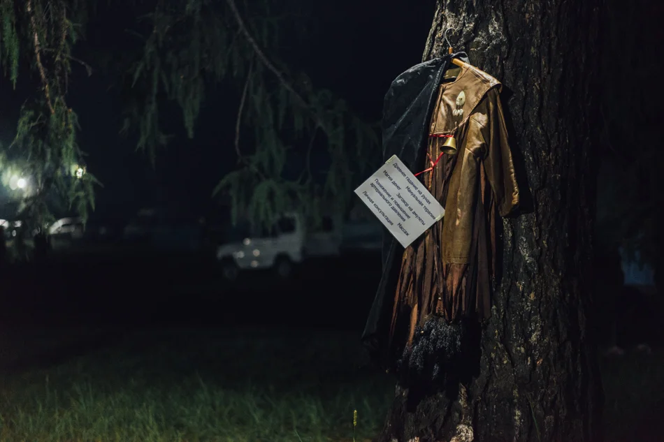 Ljudmila's shaman dress hangs on the tree to attract potential customers. The sign says: "Ancient fortune telling on stones. Manual therapy. Magic of money. Putting a spell on amulets. Reducing and rising of the blood pressure. Massage. Private consultation."