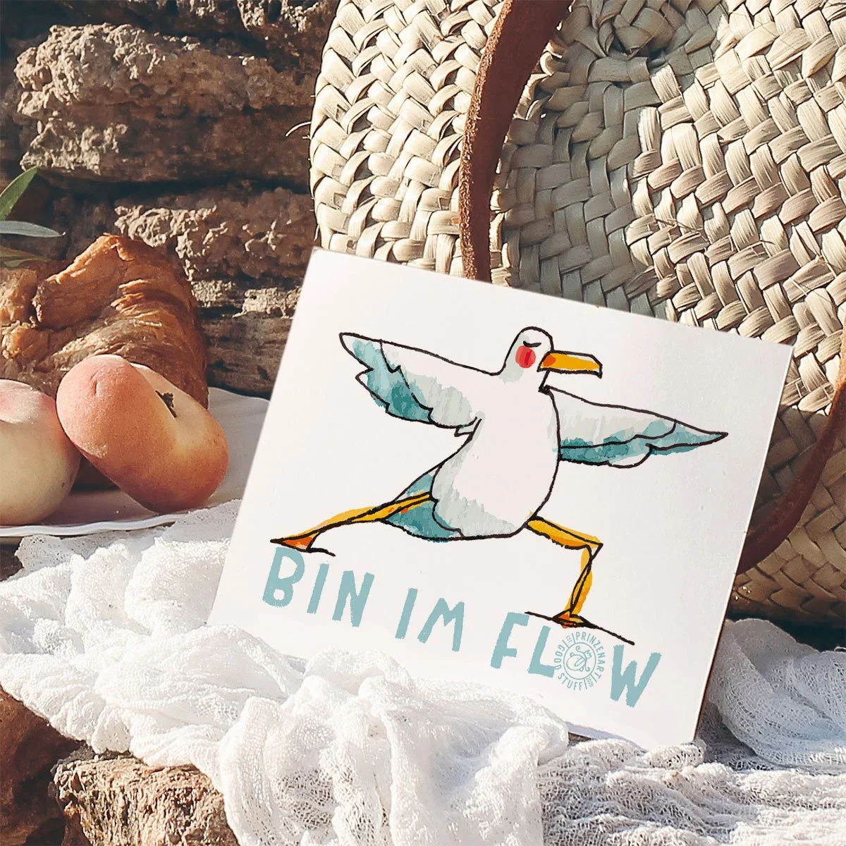 weiße postkarte mit einer yoga-möwe, asana heldin, auf tuch, vor sonnenhut