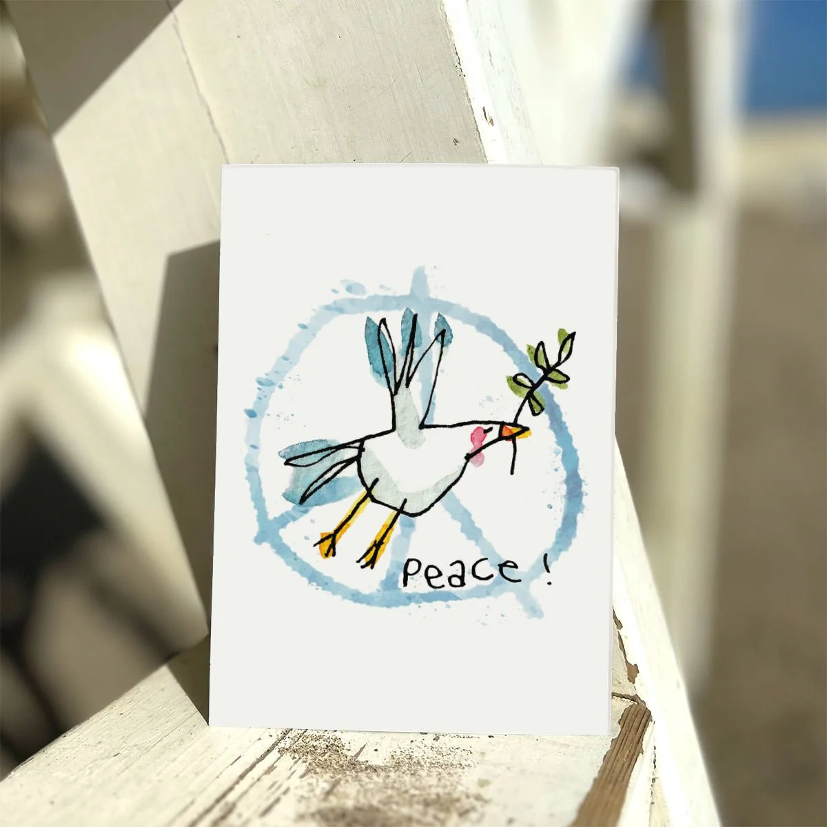 weiße postkarte mit friedensmöwe auf hellblauem peacezeichen, sonnenlicht, strand
