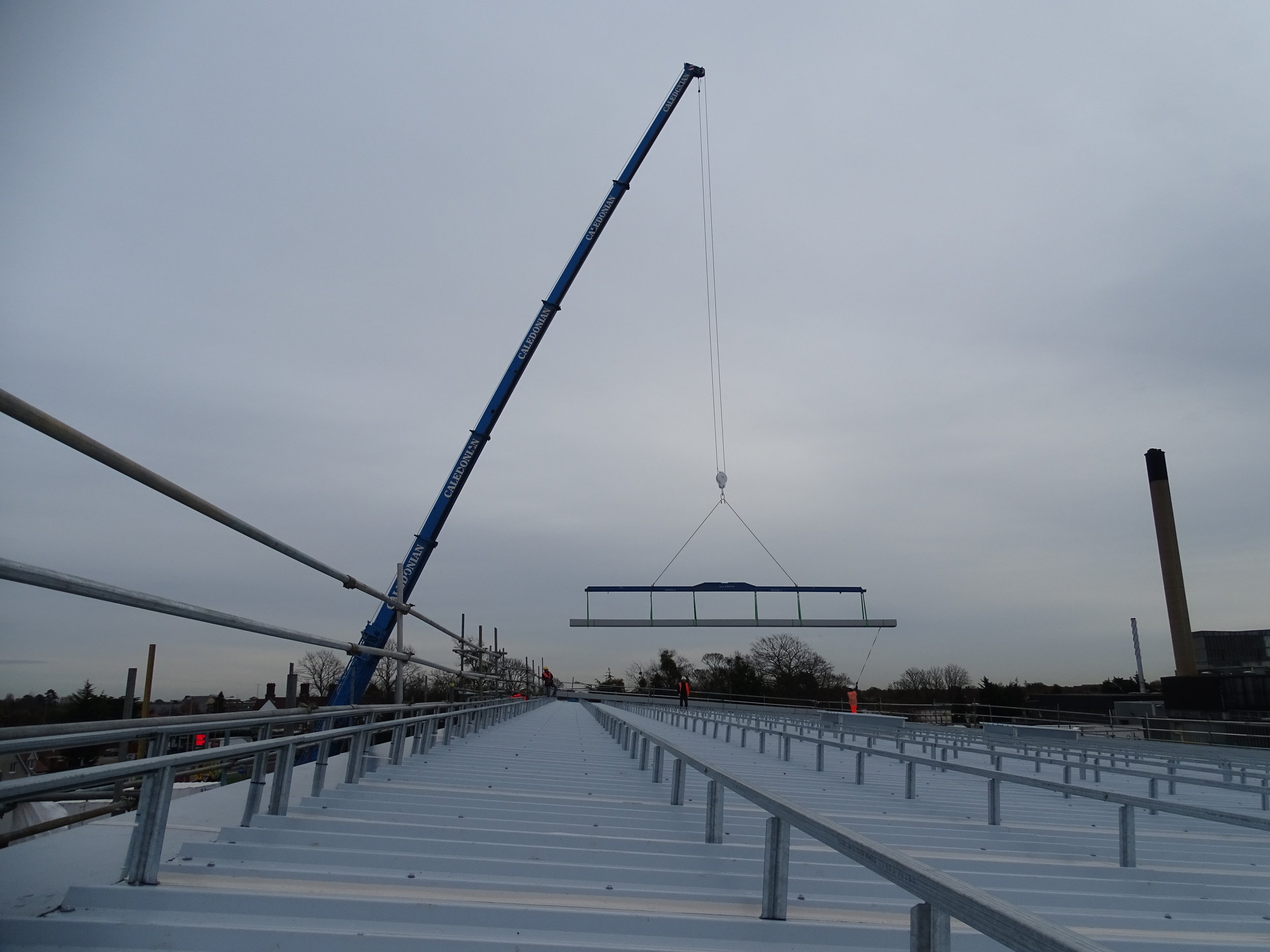 Contract crane lift of the Omnis Exteriors SpeedDeck profile standing-seam topsheets onto roof area