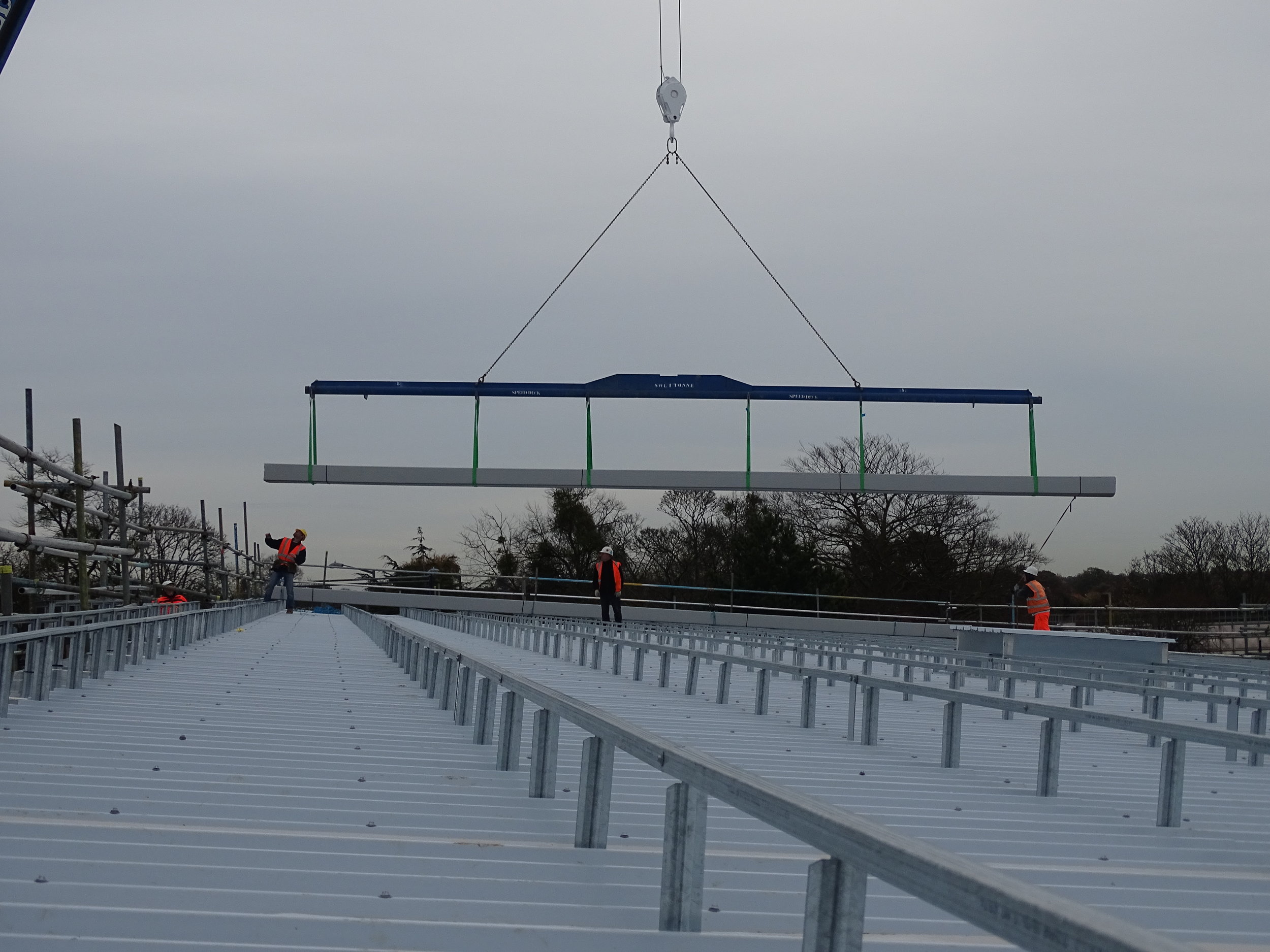 Contract crane lift of the Omnis Exteriors SpeedDeck profile standing-seam topsheets onto roof area