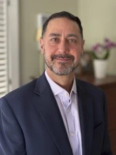 Head shot of a bearded man in a sport coat.