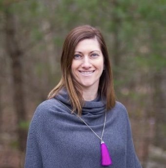 Head shot of a woman standing in a forest