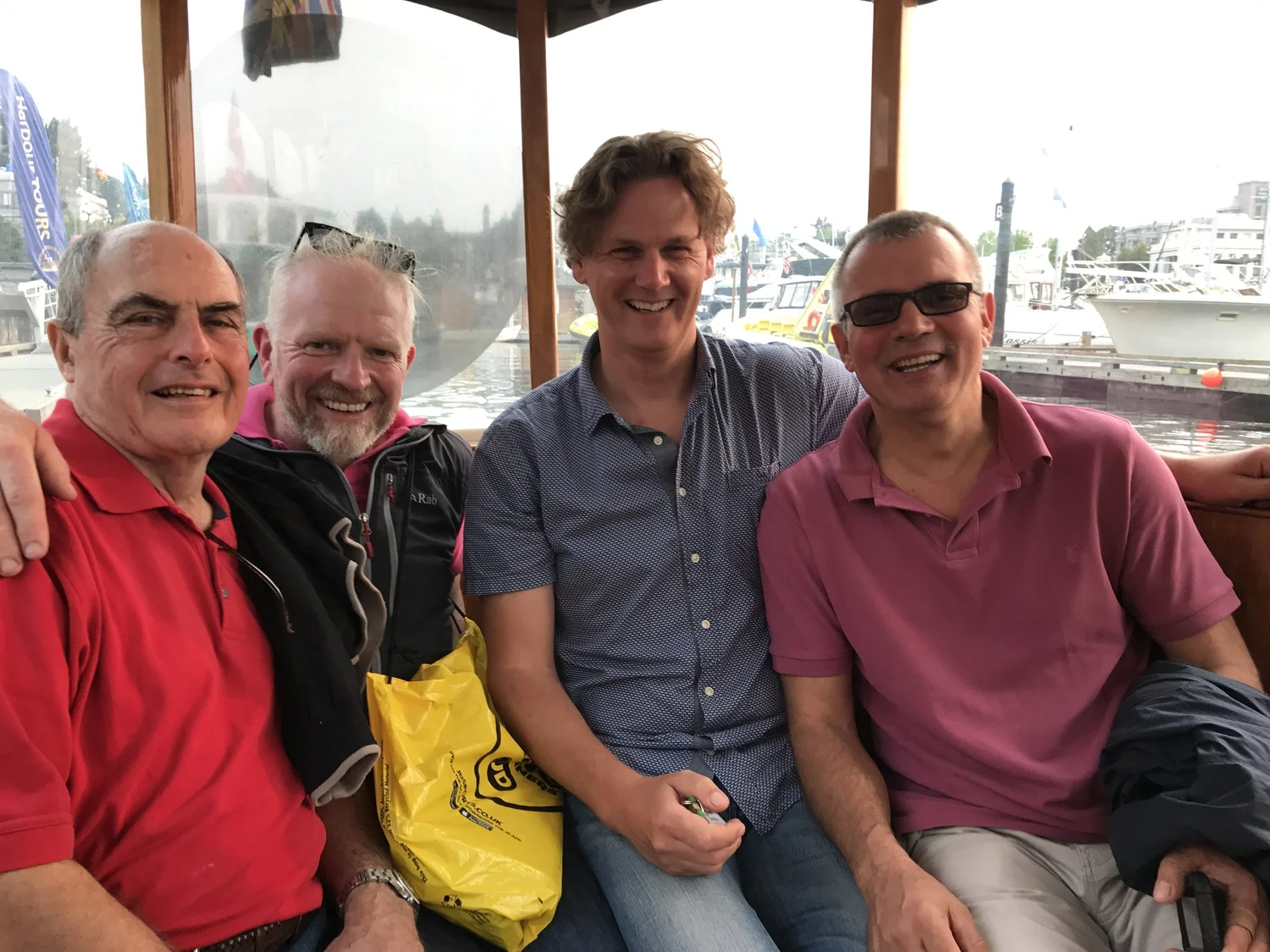 Three crew members smiling together on deck