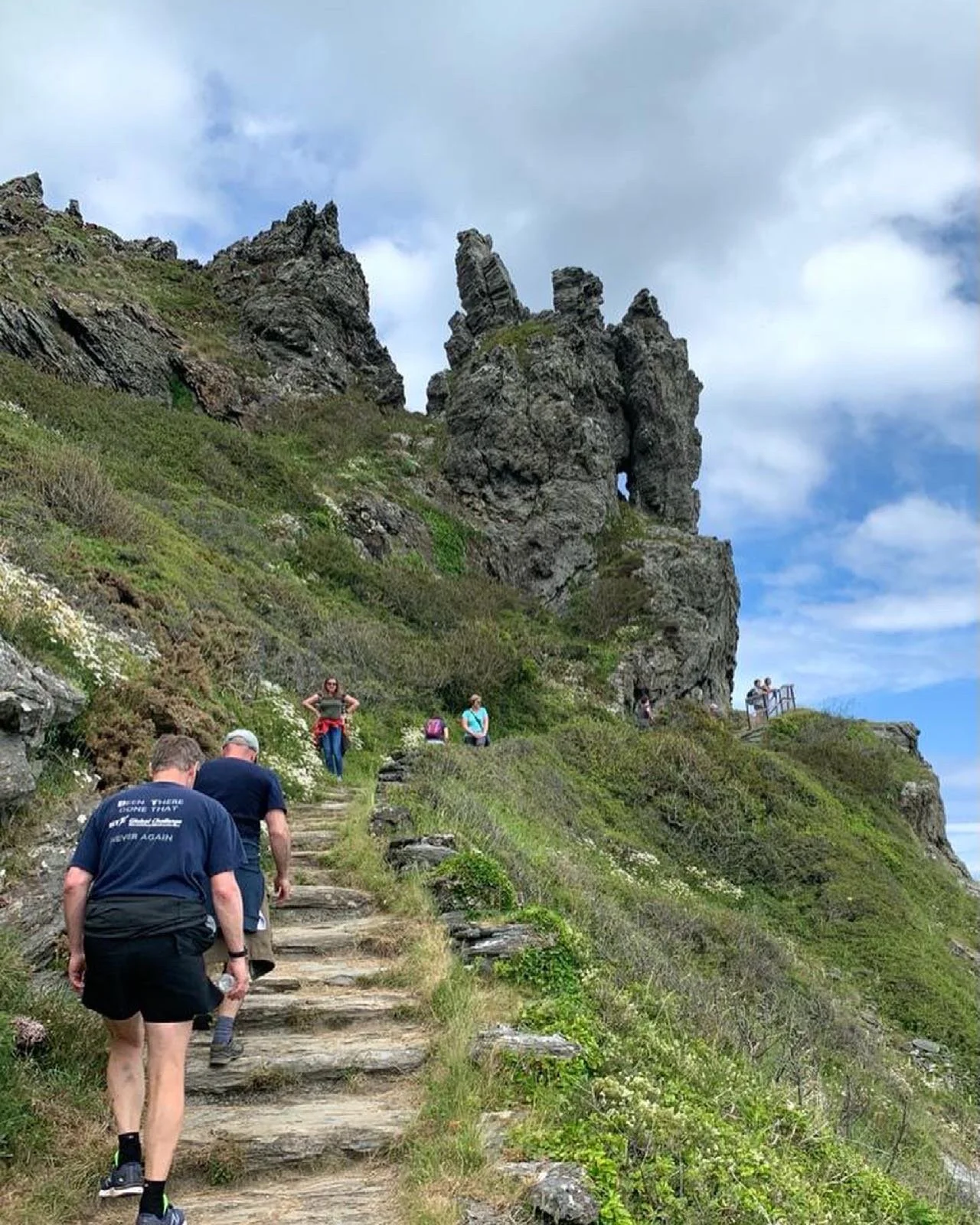 Walkers climbing a rocky coastal path