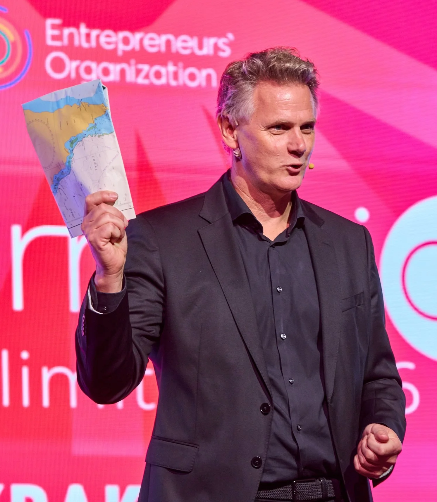 Caspar Craven on stage holding up a nautical chart: you can’t navigate a new world using an old set of charts