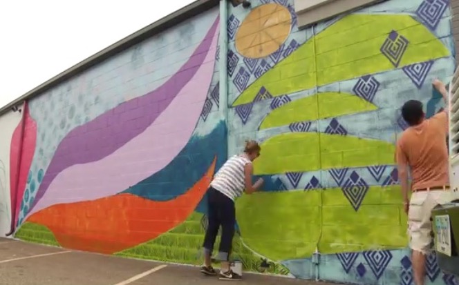 Sarah Dugger and Jon Stucky working on the mural at Be Yoga.jpg