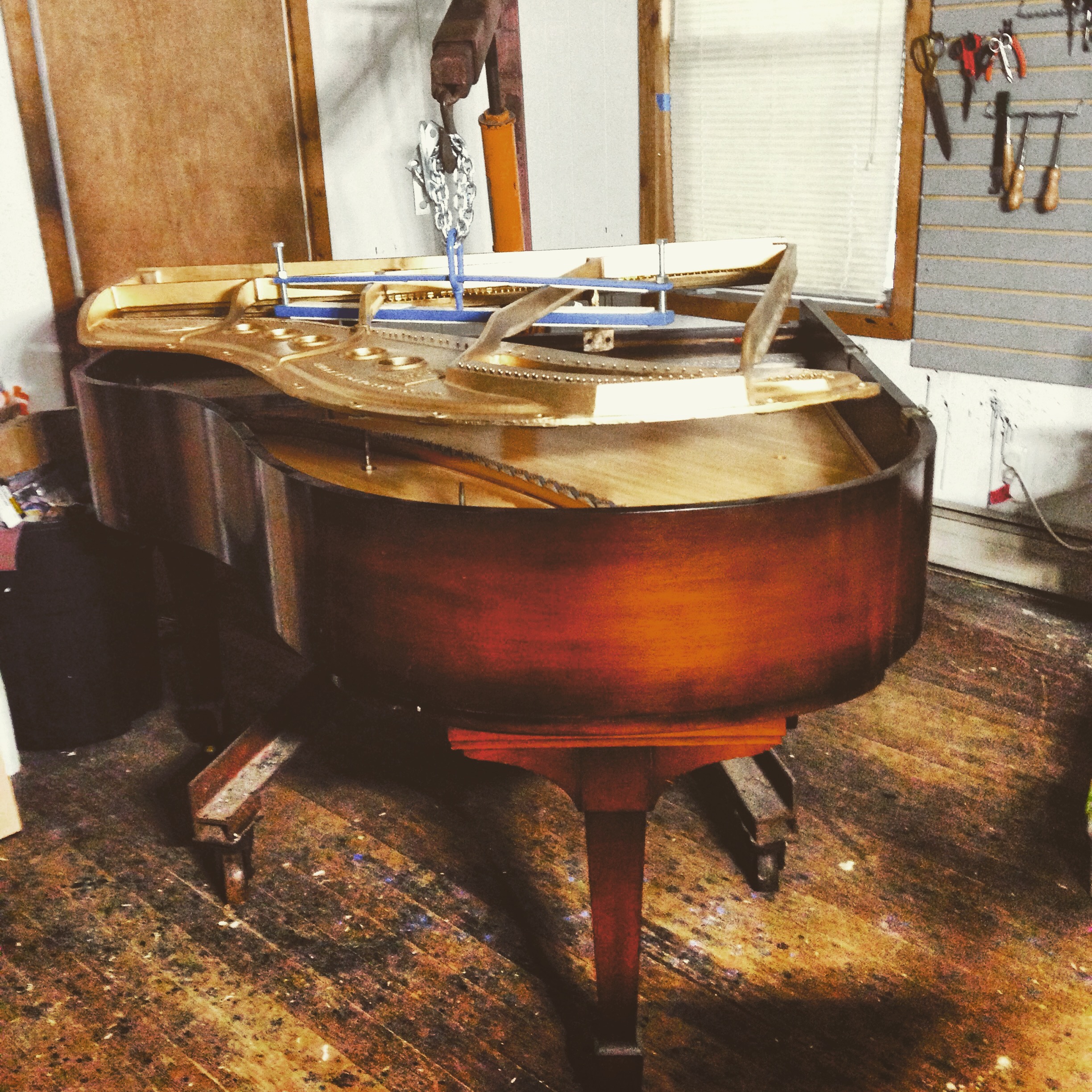 Lowering the refinished plate back into a Steinway Grand