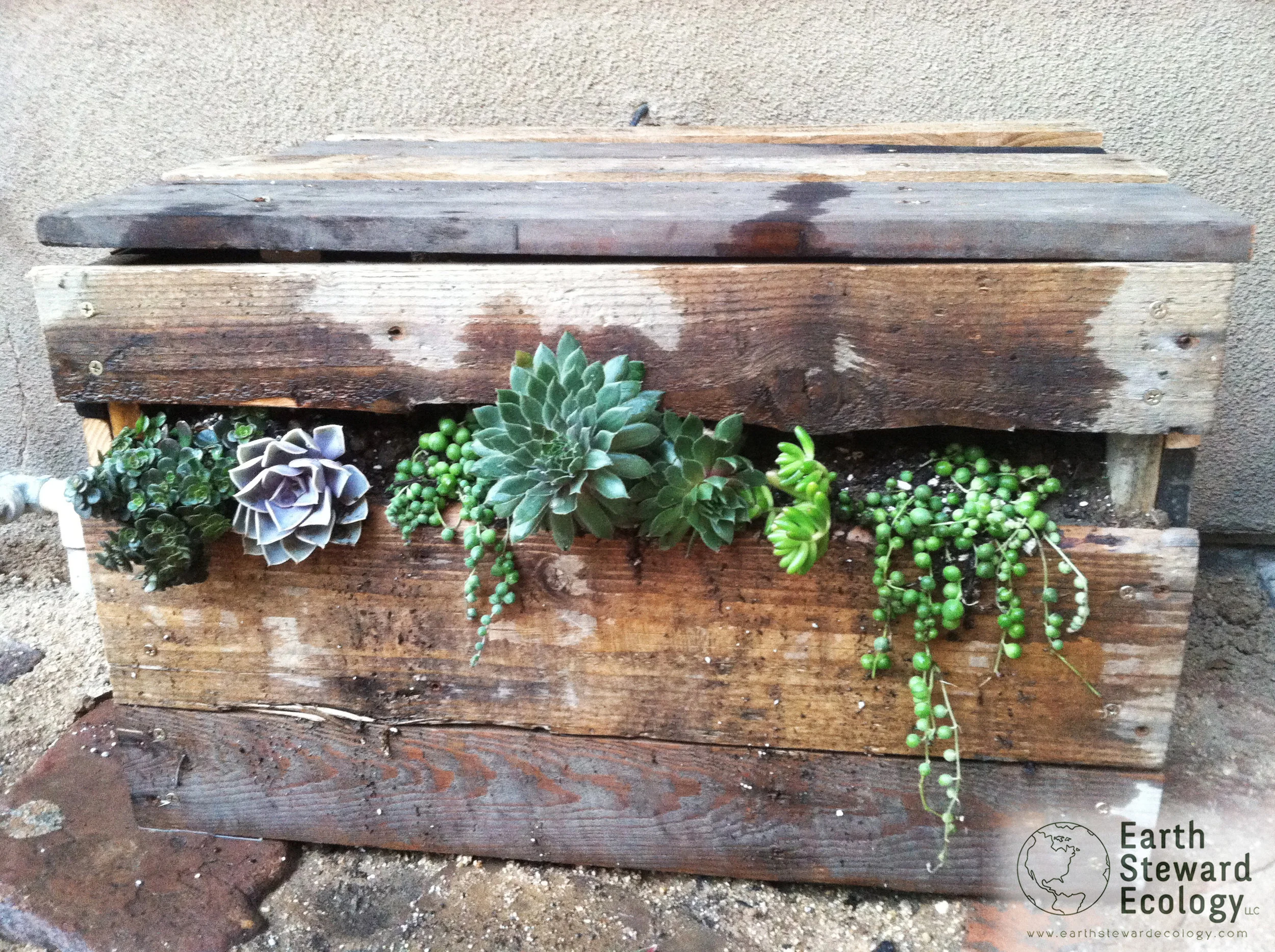 reclaimed wood from pallets was used to build this custom irrigation manifold cover.
