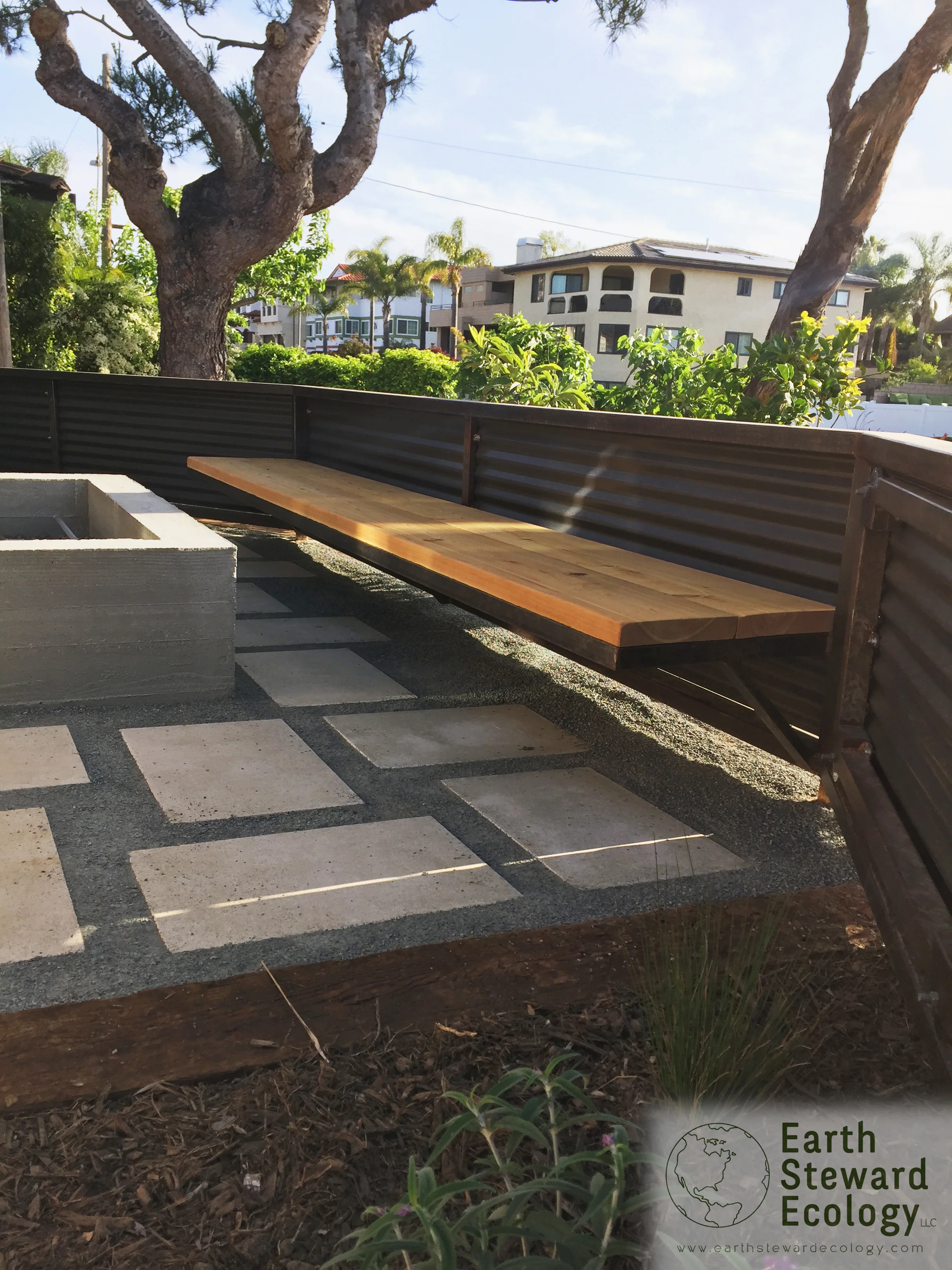 railroad ties are dug into the ground to create the perimeter of this planter