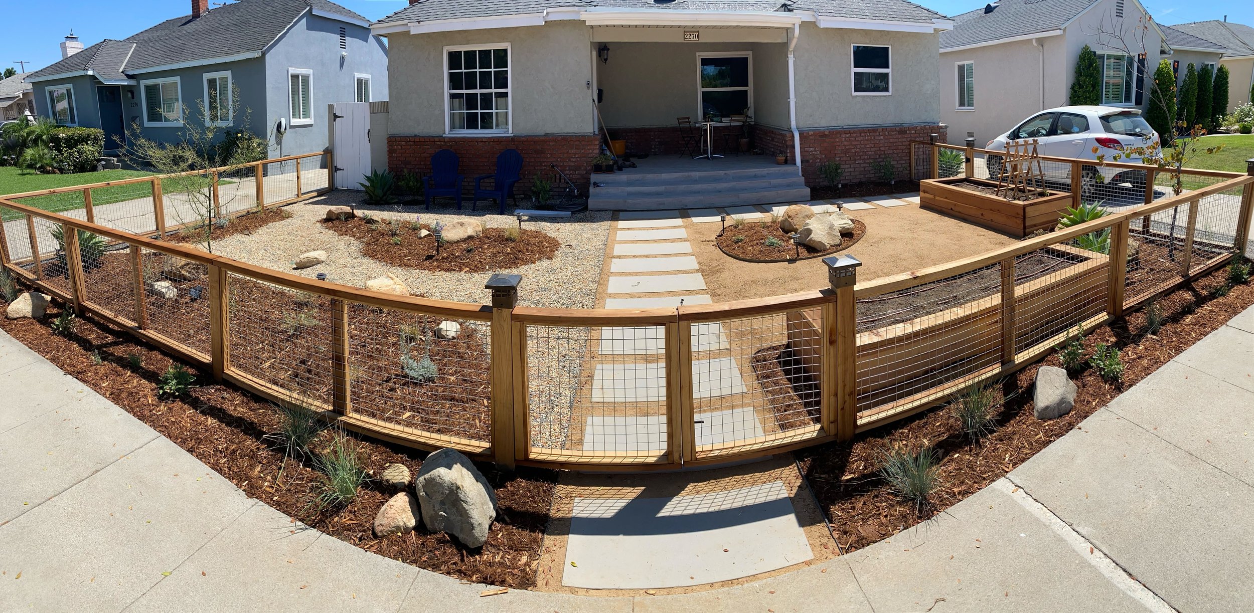 An airy lumber & mesh fence makes an inviting entry to this front yard, complete with matching custom raised beds.