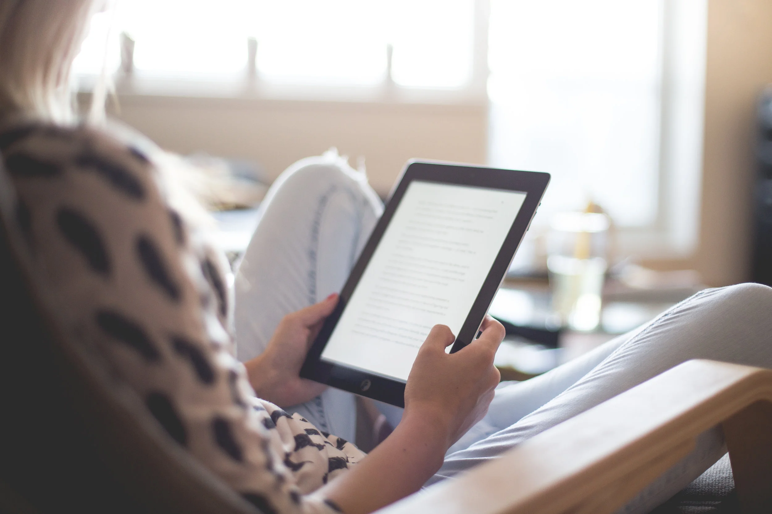 young-woman-reading-a-book-on-her-ipad-picjumbo-com.jpg