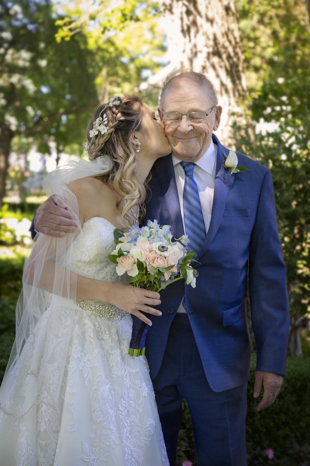 bride-kissing-grandfather-outdoor-wedding.jpg