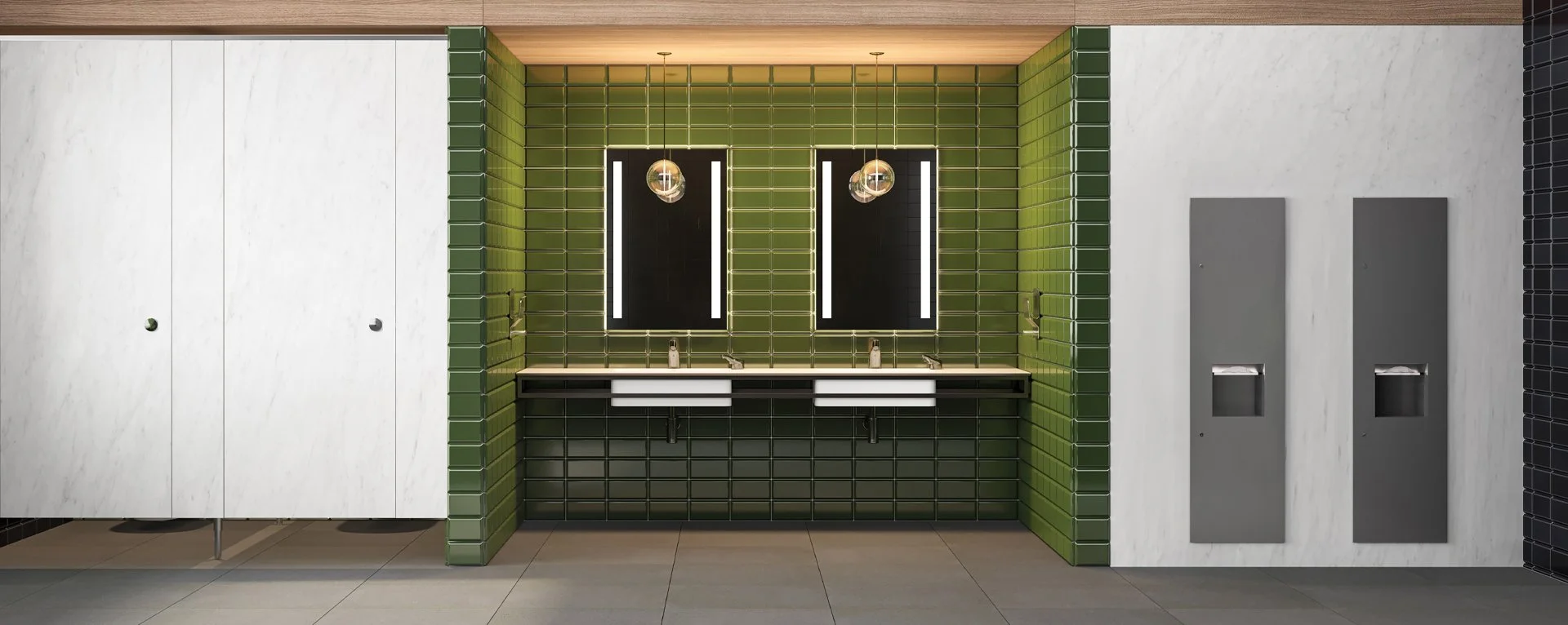 Modern restroom with green tiled wall, two mirrors with vertical LED lights, double sinks, and gray paper towel dispensers.