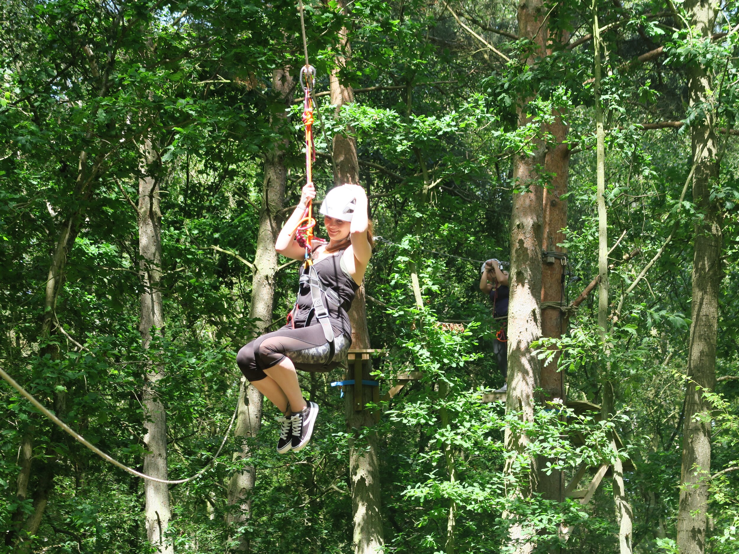 woman flying through the trees on a zip line