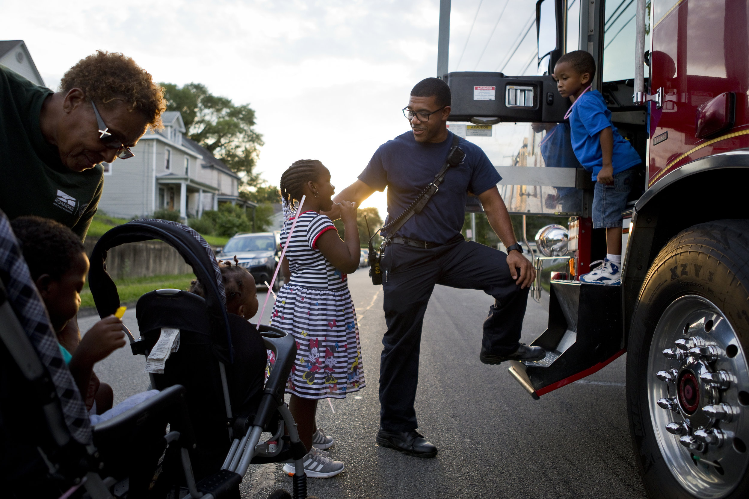 Justin Stone, a firefighter with the Roanoke Fire Department, shows kids the in's and out's of his firetruck at the Northwest Neighborhood Environmental Organization (NNEO) National Night Out Celebration in Roanoke, Va. on Aug. 7, 2018.