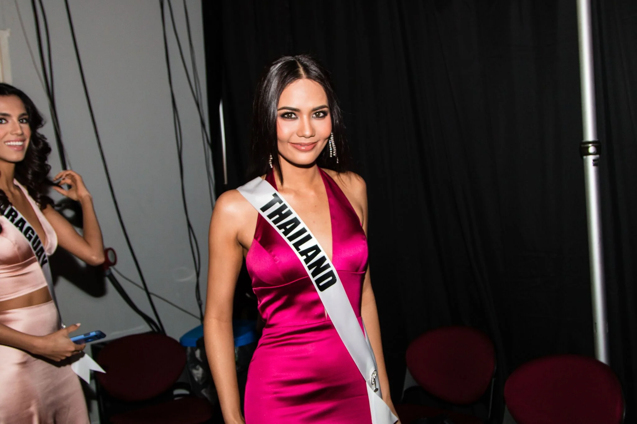 Miss Universe Thailand Chalita Suansane takes a quick snap before heading onstage while Miss Universe Paraguay Andrea Melgarejo photobombs!