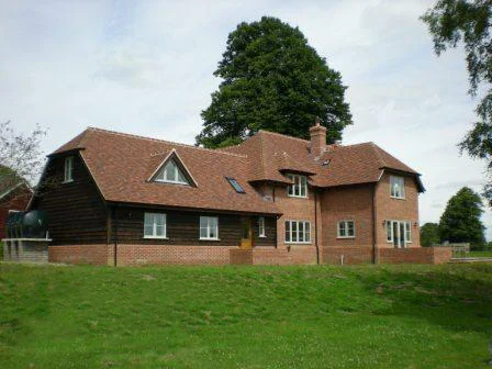 An example of a replacement dwelling in a rural location prior to terraces and landscaping. A former gardener's bungalow which can just be seen on the left hand side of the picture is to be demolished when the new house is complete and occupied.