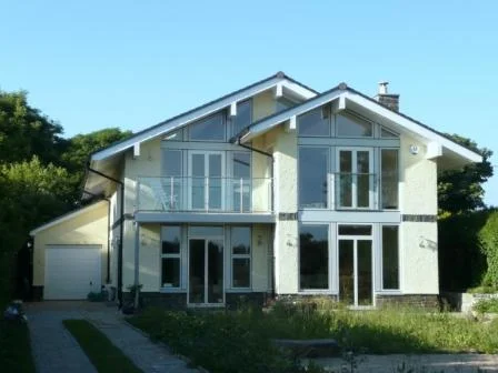 New house on the Gower peninsula, replacing a modest bungalow. The glazed gable end overlooks National Trust land and the sea beyond. In the extreme coastal conditions it even requires wind-posts to secure the roof to the foundations.