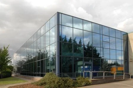 A PLC with a larger 1970's office building and warehouse required additional office facilities. The solution was to construct a new building linked to the warehouse with a new entrance and central core between the two.