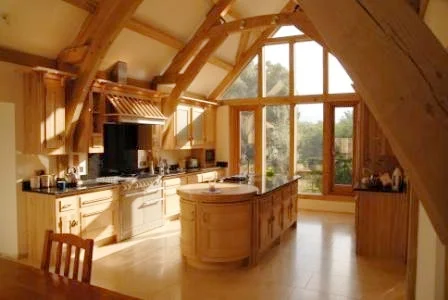 Interior view showing kitchen in Cotswold House with vaulted green oak structure.