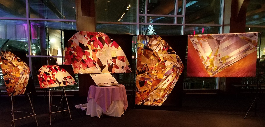 gemstone quilt artwork display at WJA exhibit in New York City at night