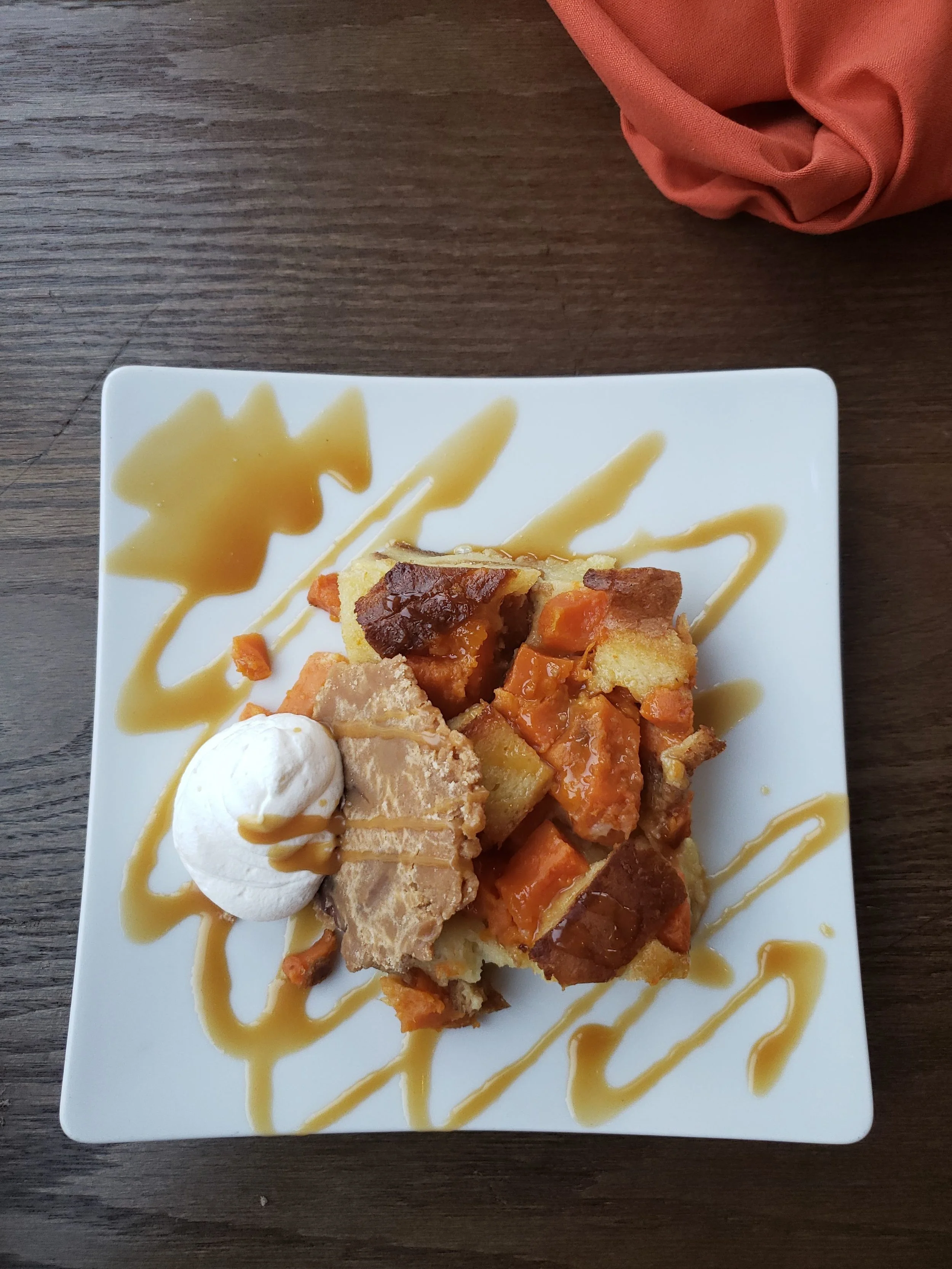 sweet potato bread pudding with spiced praline, bourbon caramel and whipped cream.