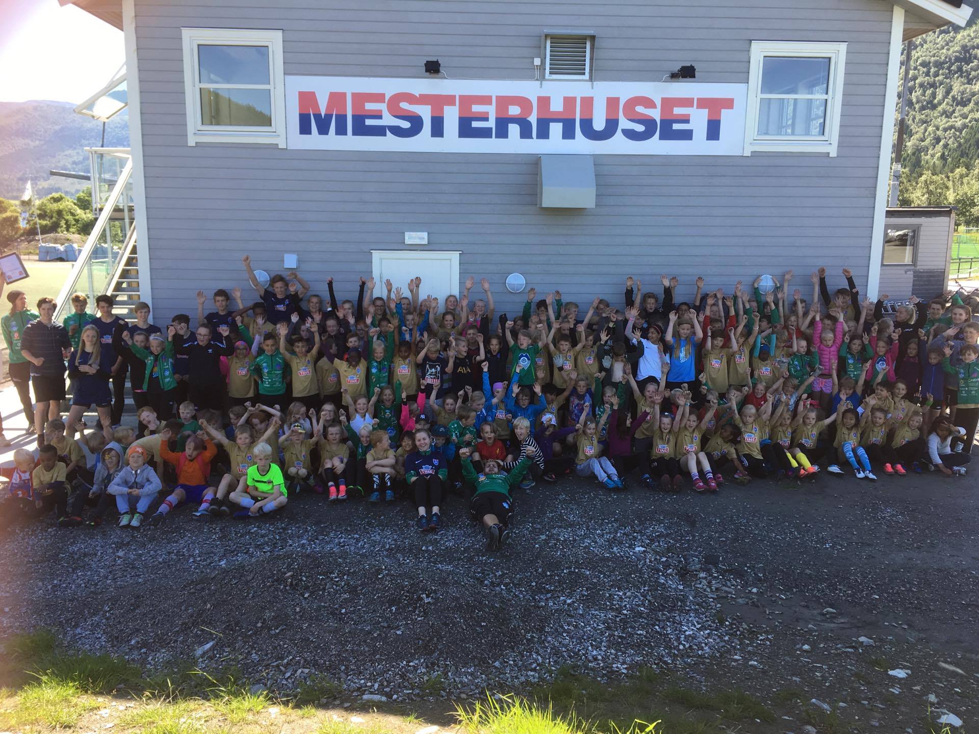 Her er glade og spreke deltakarar i Tines fotballskule 2017 framfor Mesterhuset. Foto: Solveig Storeide.