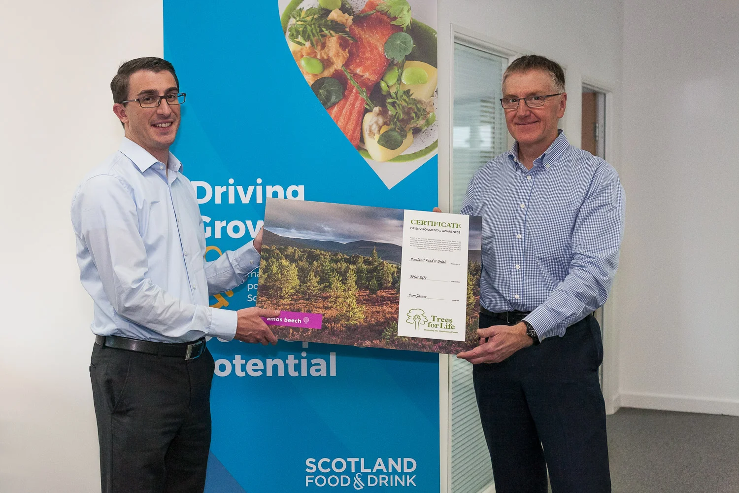 Operations director Roy James hands over the Trees for Life certificate to Dennis Overton, chairman of Scotland Food and Drink