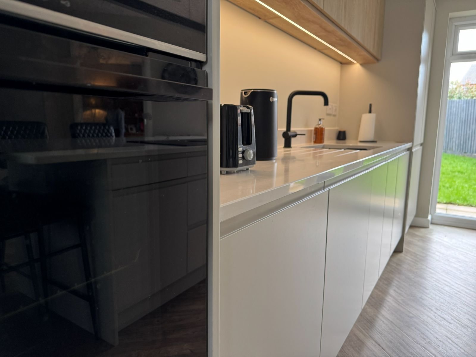 Contemporary open-plan kitchen renovation by Rose Kitchens in Stretton, featuring bespoke integrated storage and modern lighting.