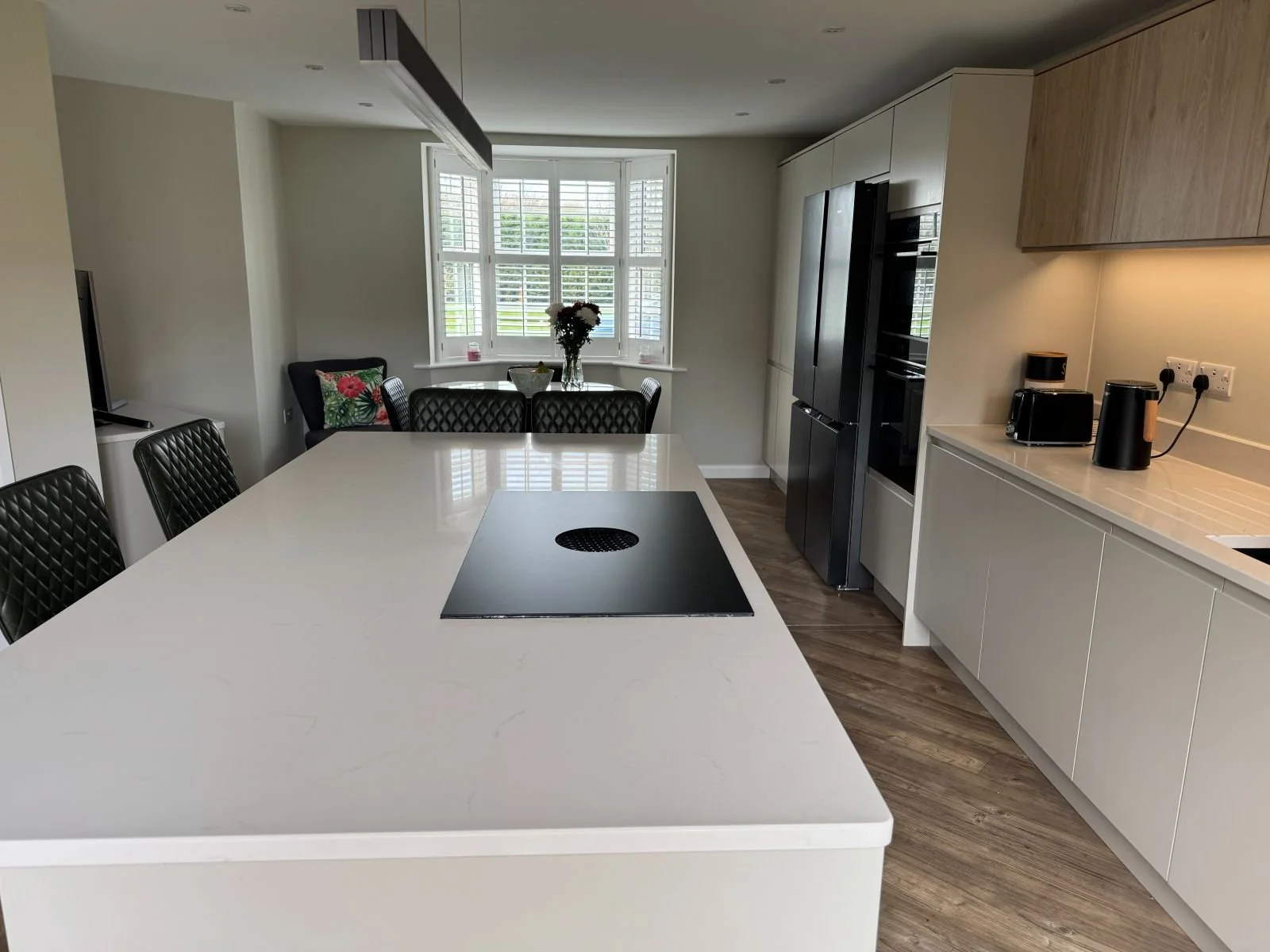 A sleek, modern handleless kitchen design and installation by Rose Kitchens in the village of Rolleston-on-Dove.