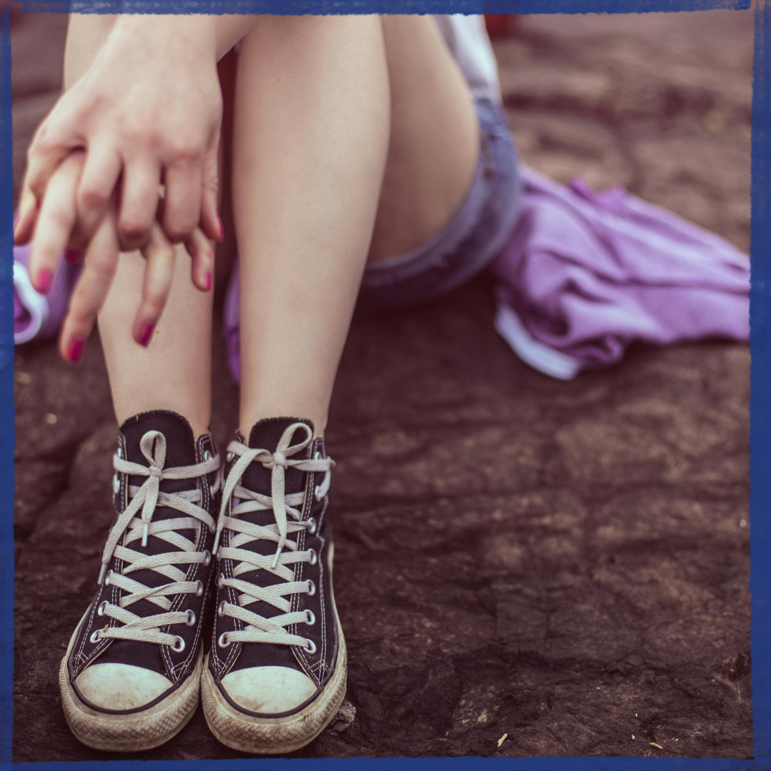 teenage girl sitting on ground feeling judged